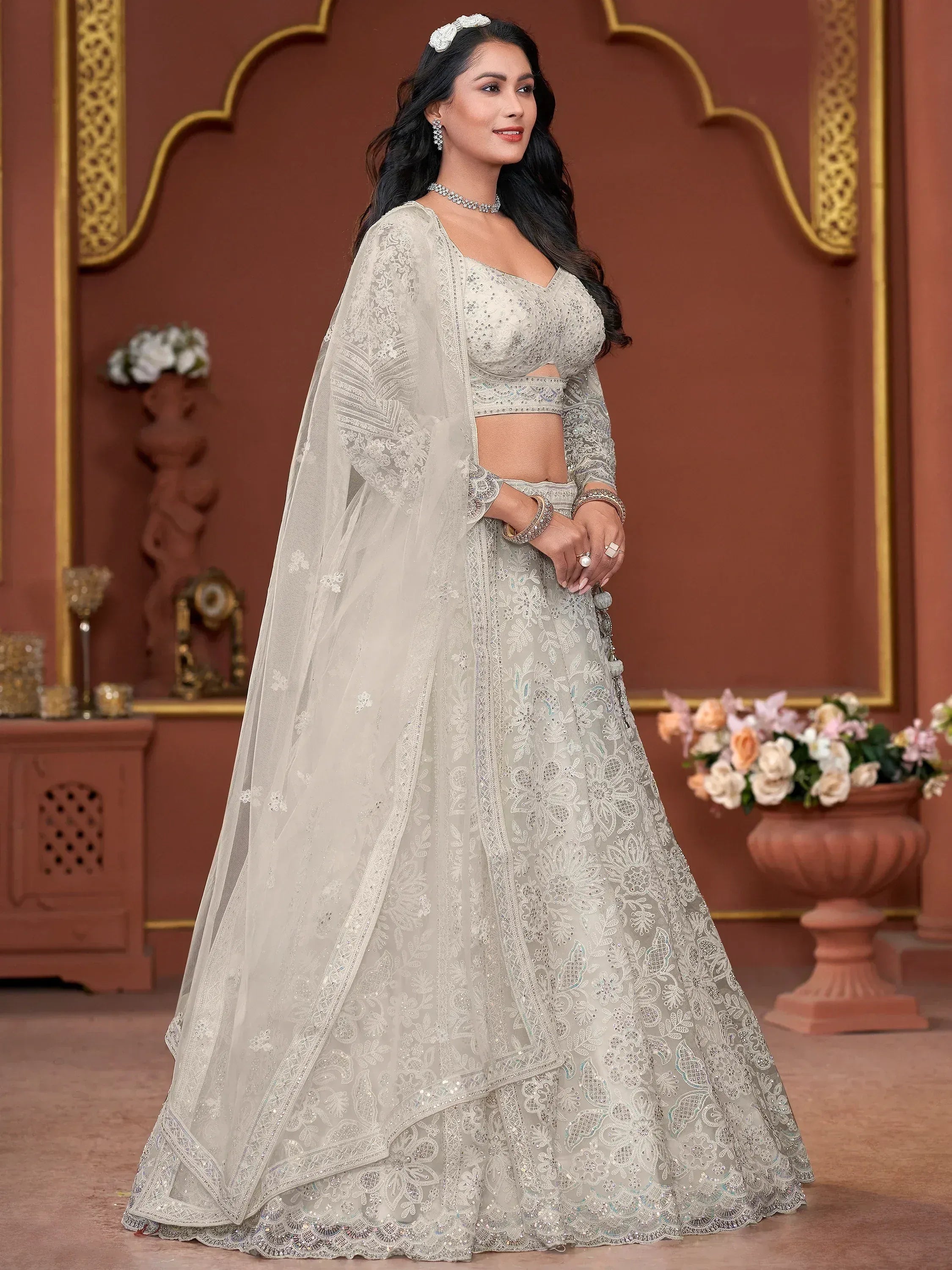 Elegant off-white embroidered lehenga choli with sheer dupatta, perfect for Indian weddings and festive occasions.