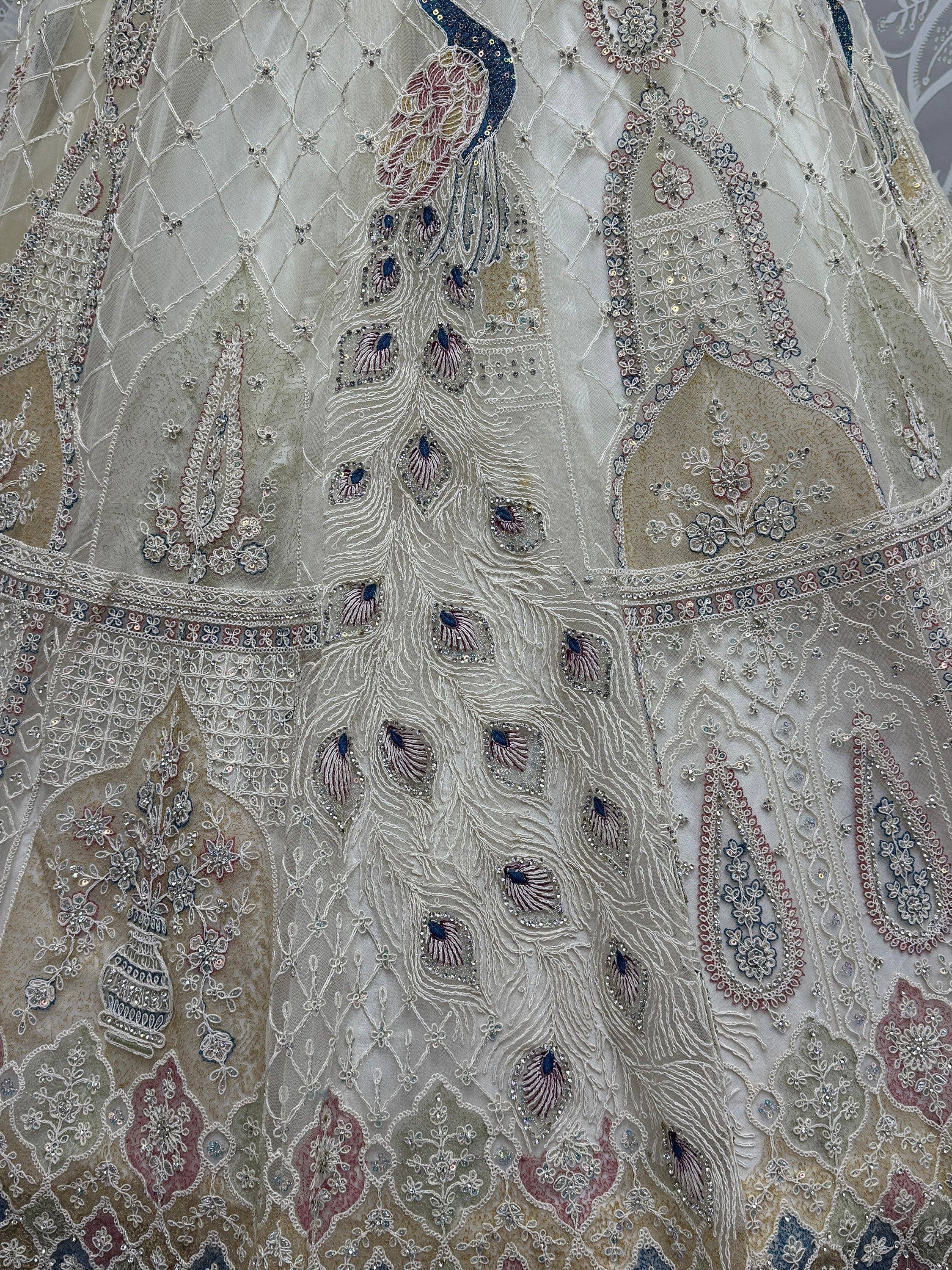Elegant white lehenga with intricate peacock embroidery and floral sequin details, perfect for Indian ethnic wear.