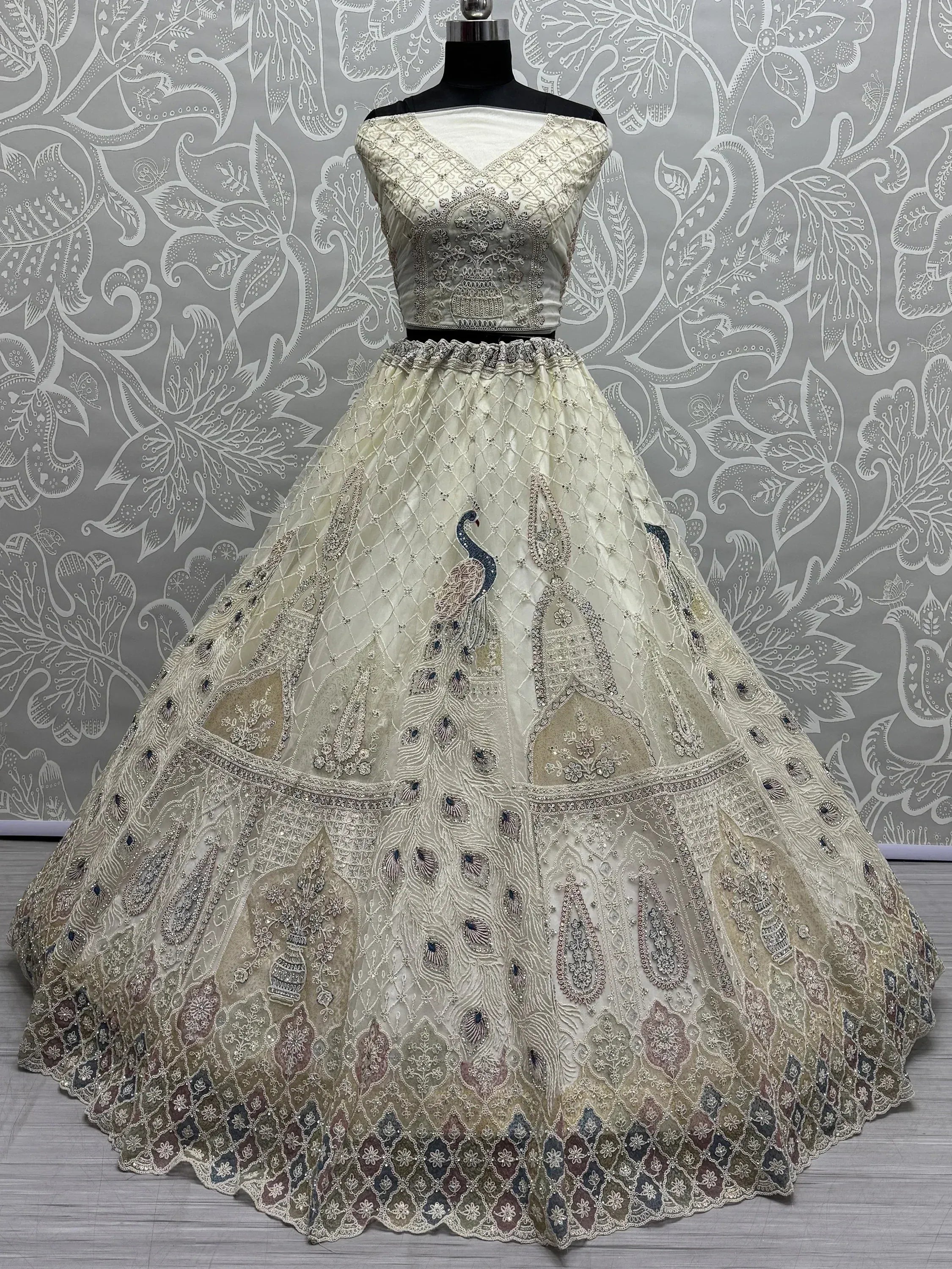 Elegant ivory lehenga choli with peacock embroidery, perfect for Indian weddings and festive occasions.