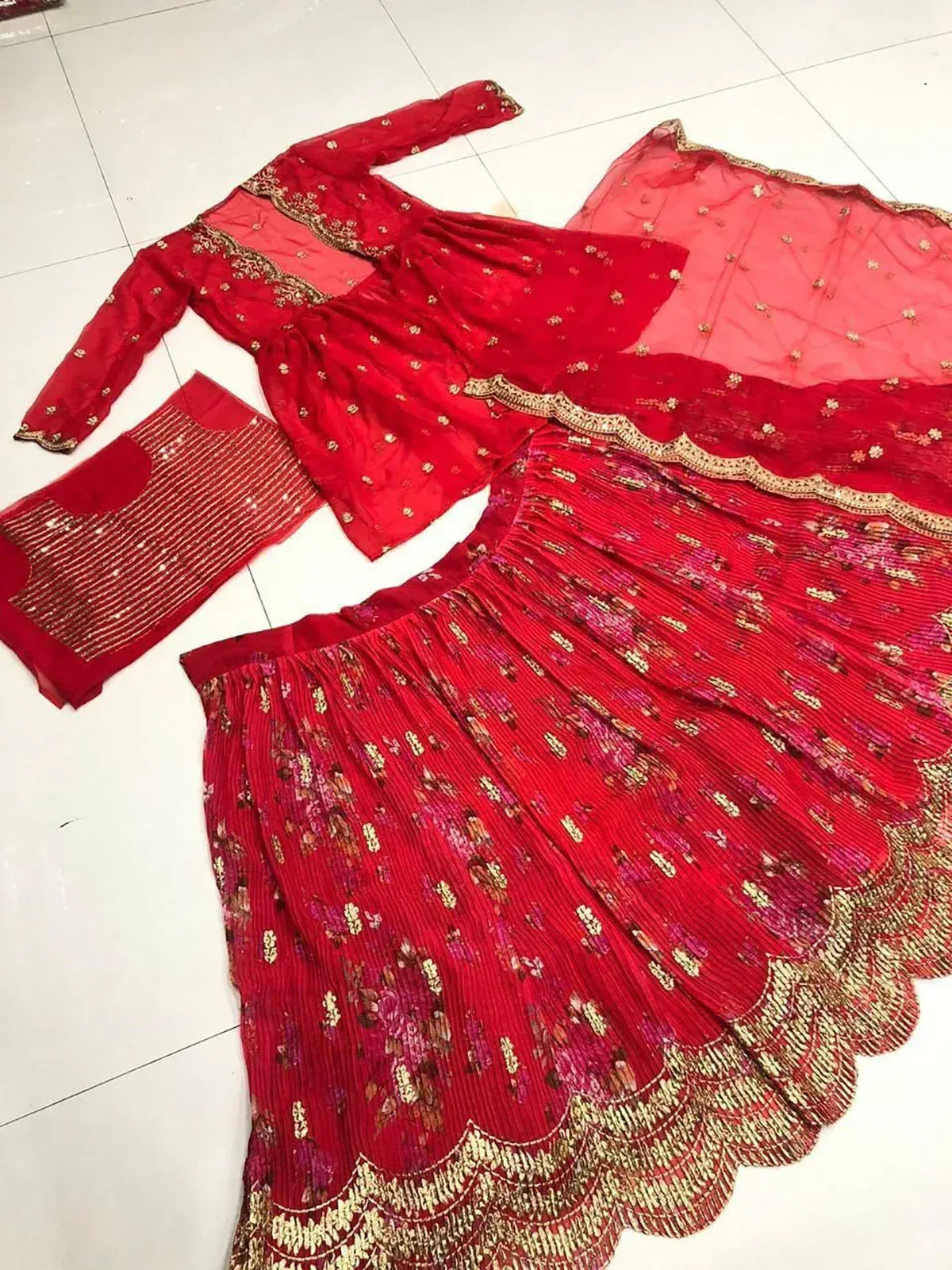 Red embroidered lehenga choli with gold detailing and floral print, perfect for Indian ethnic wear