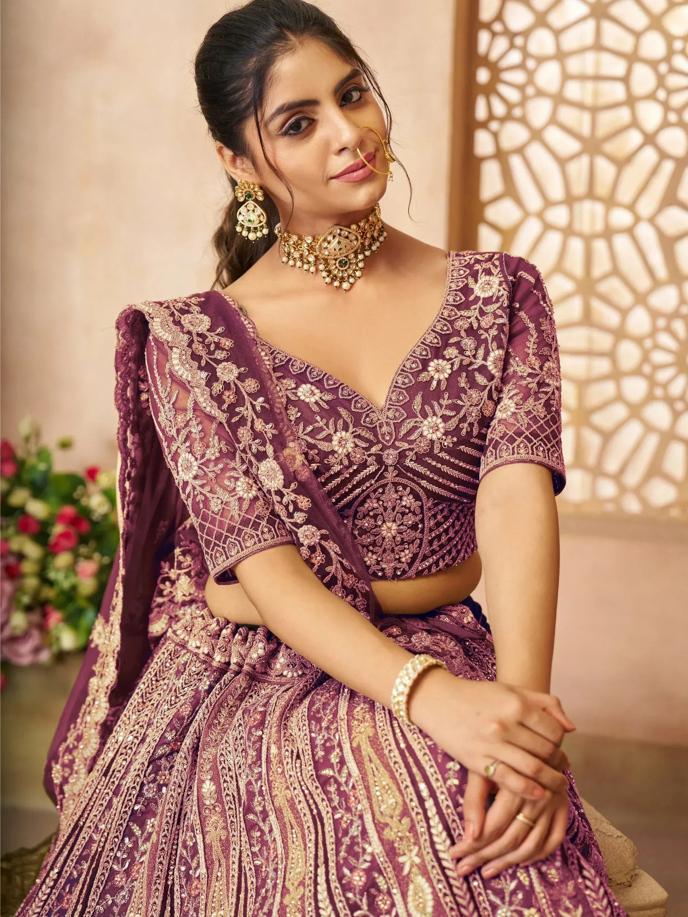 Elegant purple embroidered lehenga choli with gold detailing, perfect for Indian weddings and festive occasions.