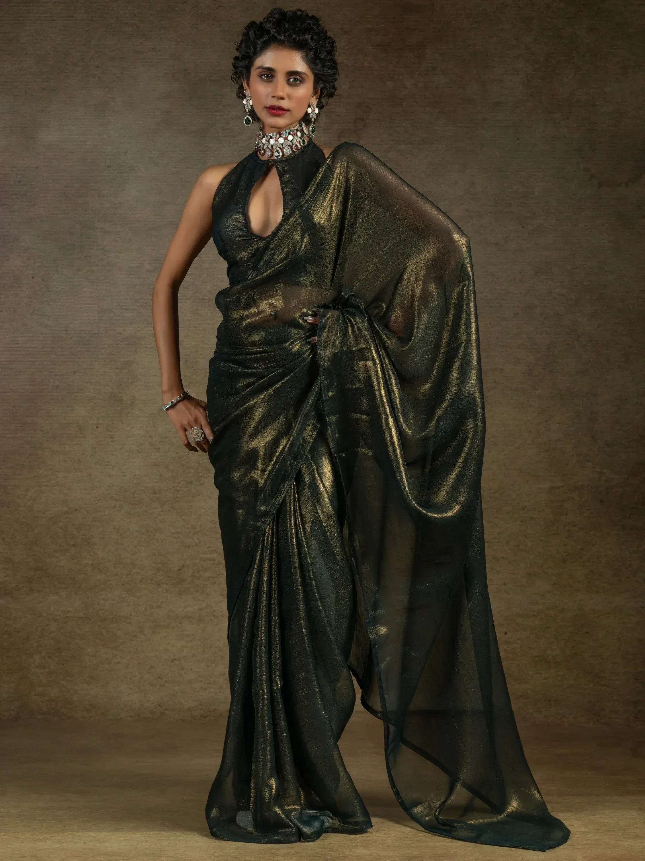 Elegant black and gold saree with halter neck blouse, perfect for Indian ethnic wear occasions