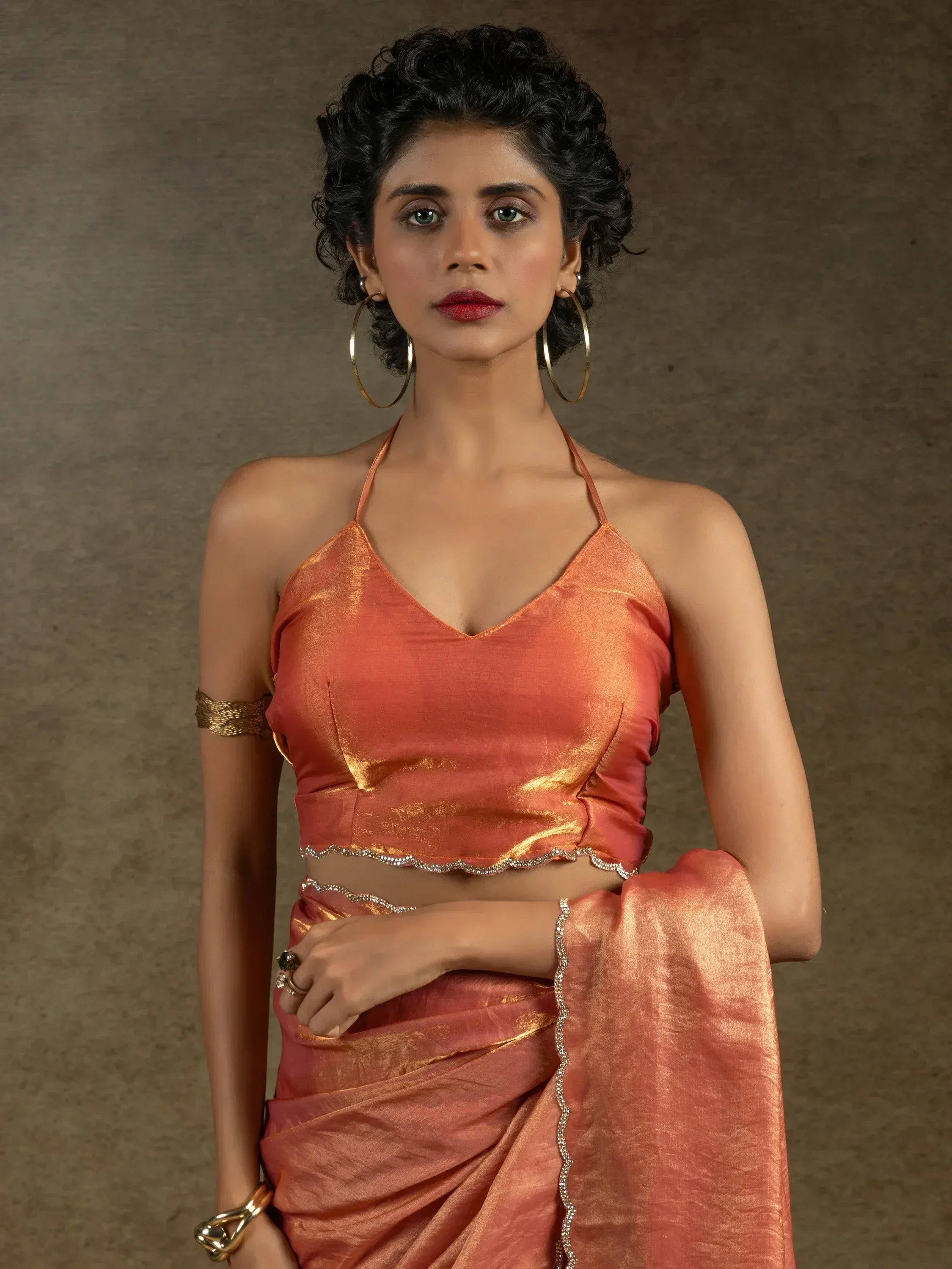 Woman in peach orange saree with halter neck blouse, ethnic wear for festive occasions