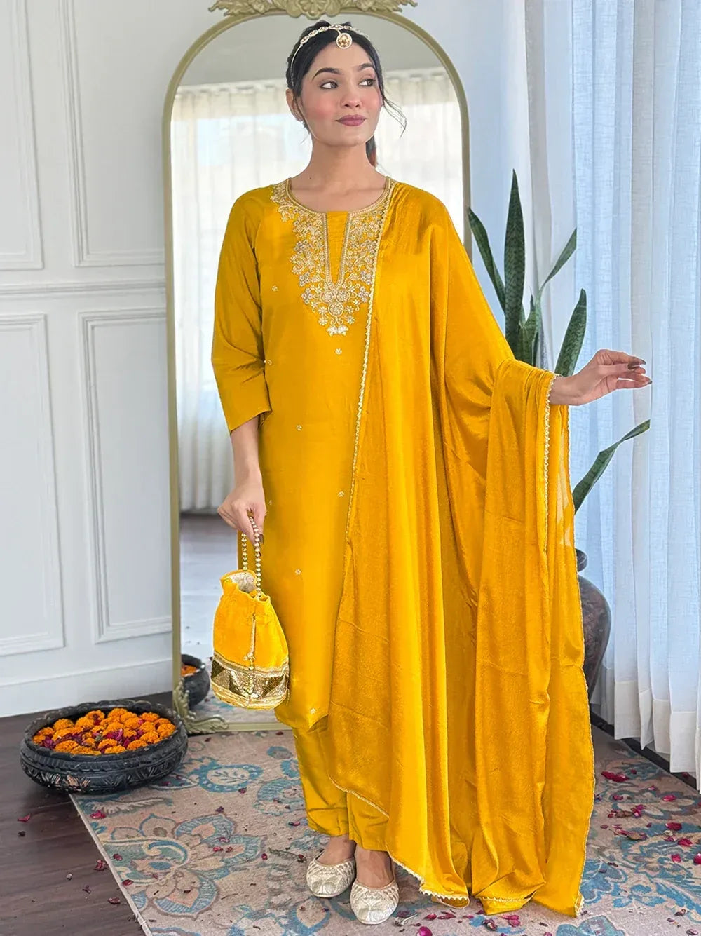 Yellow velvet ethnic kurta with gold embroidery, matching dupatta, and potli bag for festive occasions
