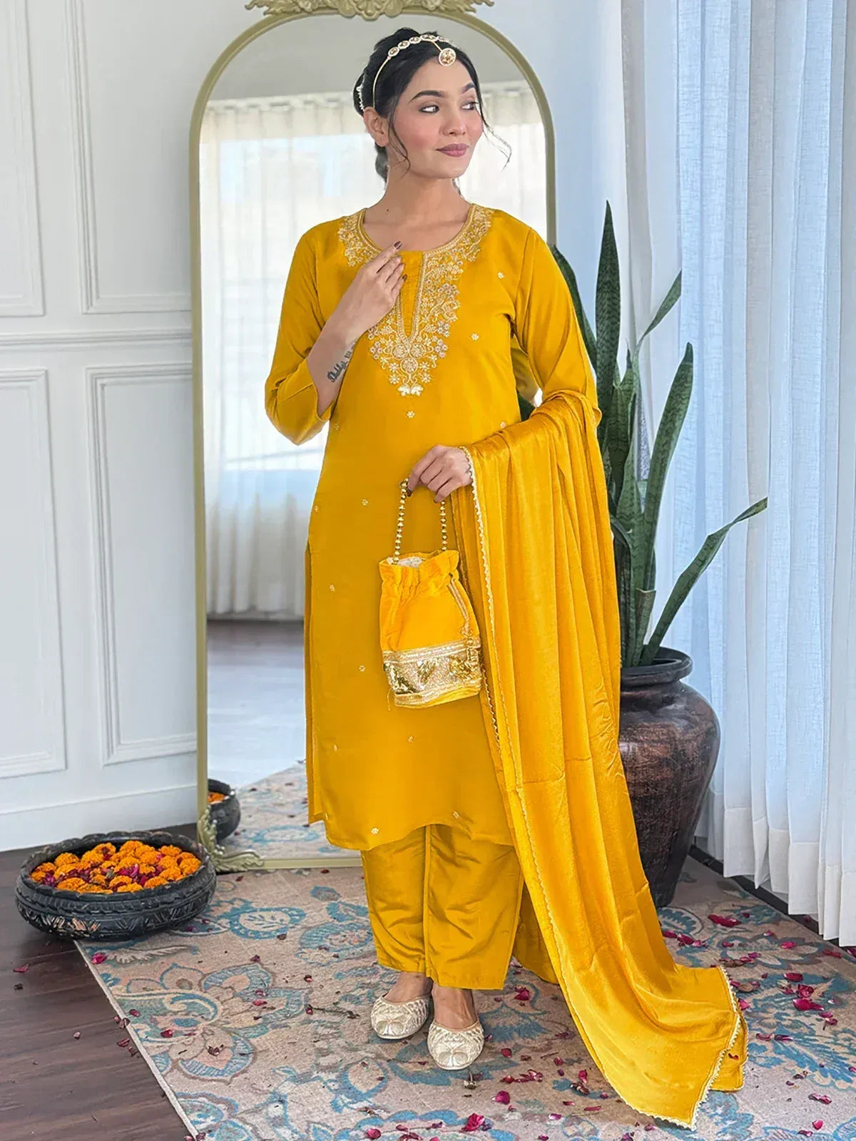 Yellow embroidered salwar kameez with matching dupatta and potli bag, perfect for festive occasions