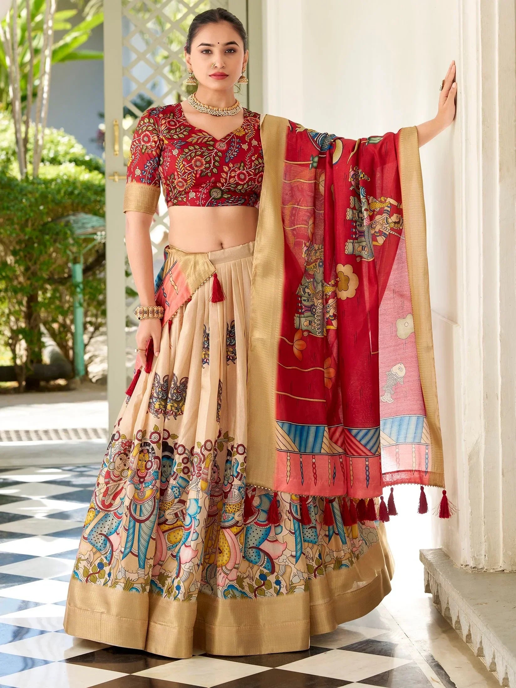 Woman in vibrant red and beige printed lehenga choli with ethnic motifs, perfect for Indian weddings or festivals