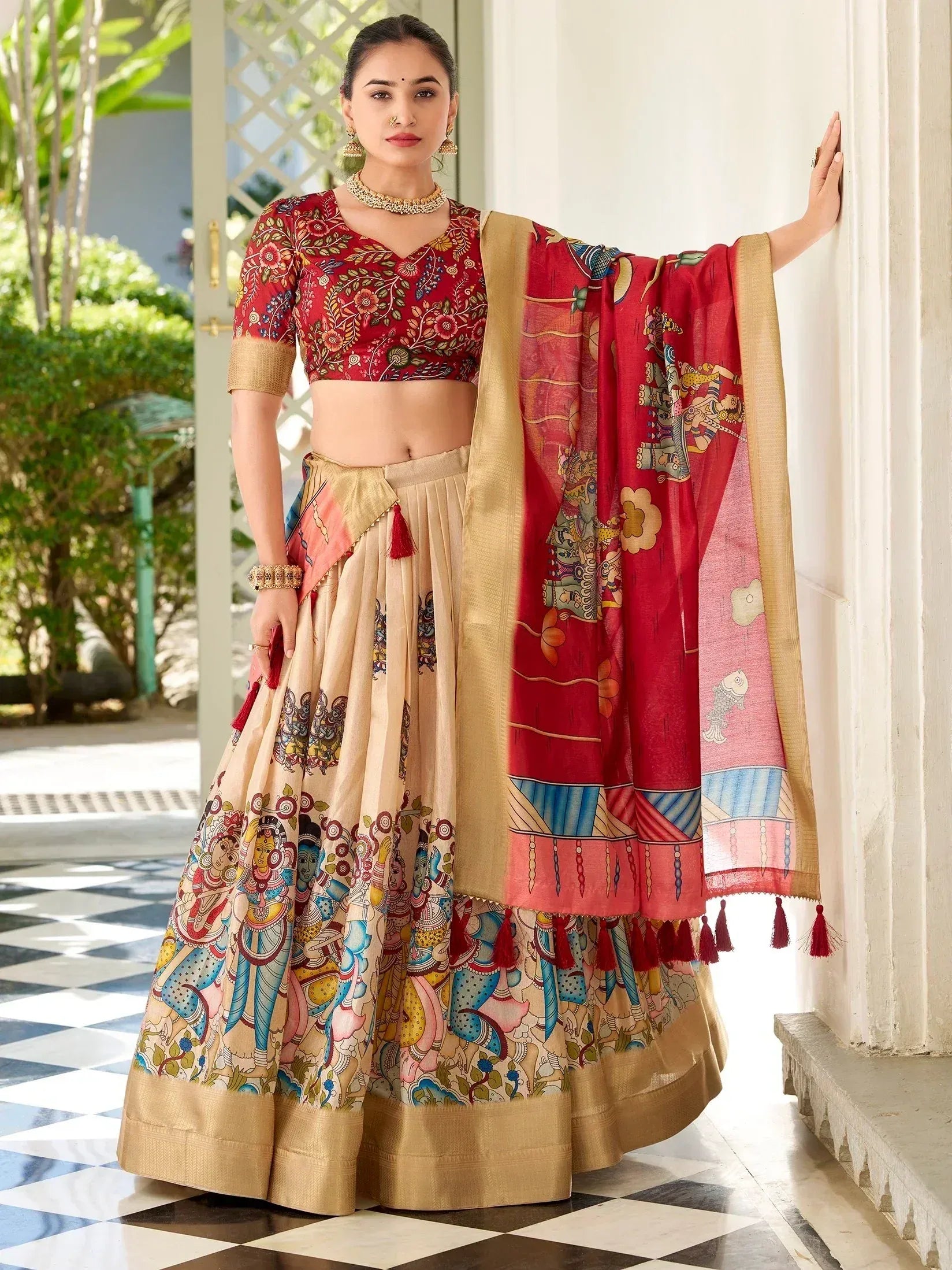 Woman in vibrant red and beige printed lehenga choli with ethnic motifs, perfect for Indian weddings or festivals