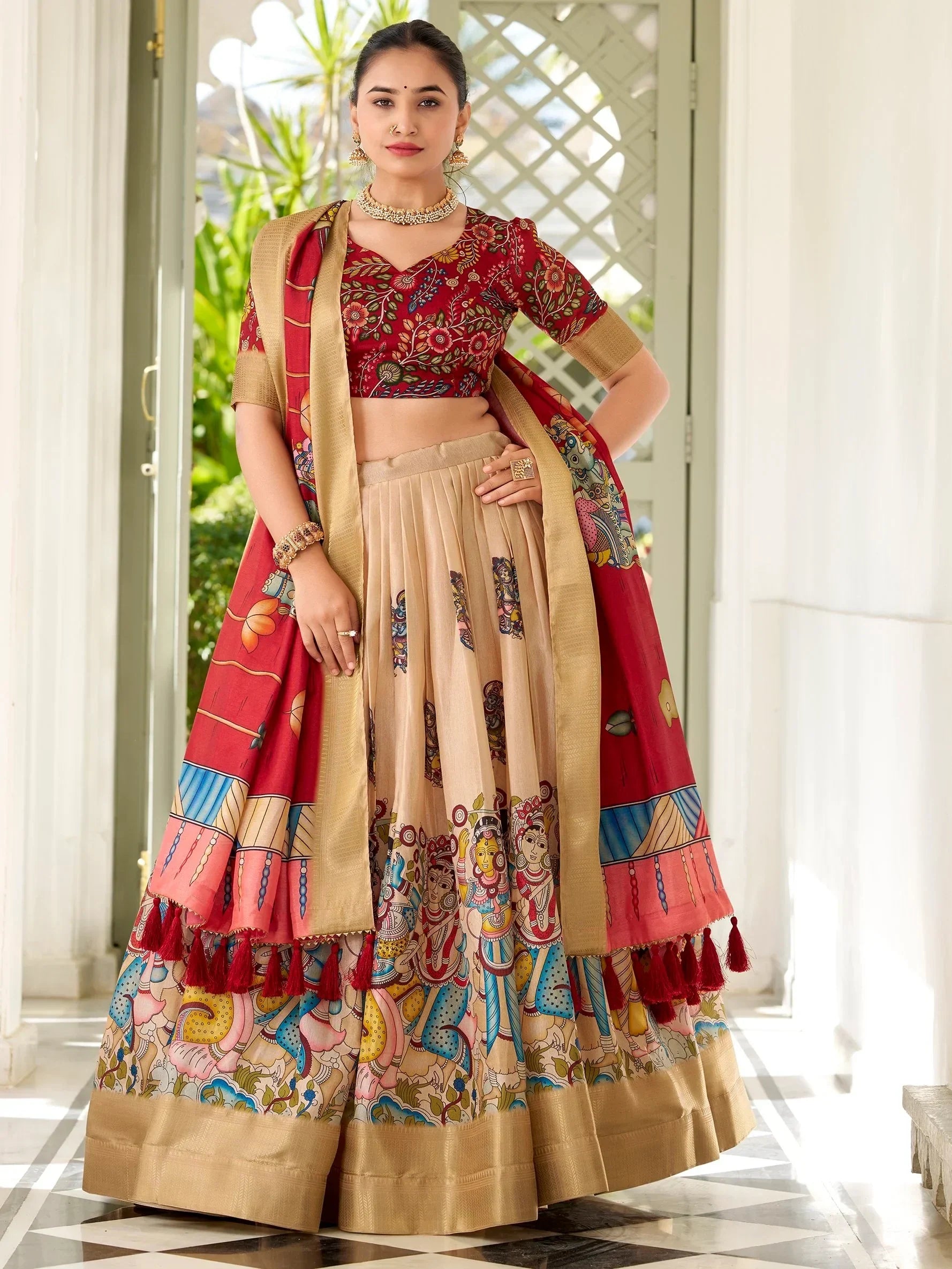 Red and beige printed lehenga choli with ethnic motifs and tassels, perfect for Indian festivals and weddings.