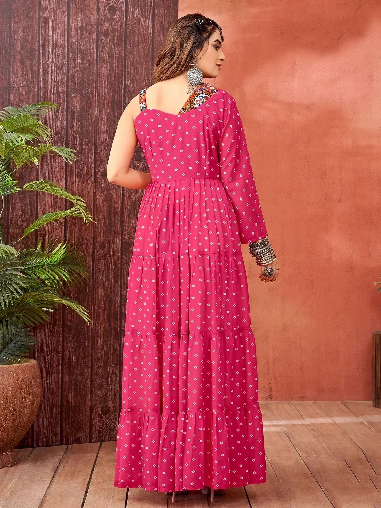 Pink ethnic gown with white diamond print, tiered skirt, and embroidered neckline for festive occasions