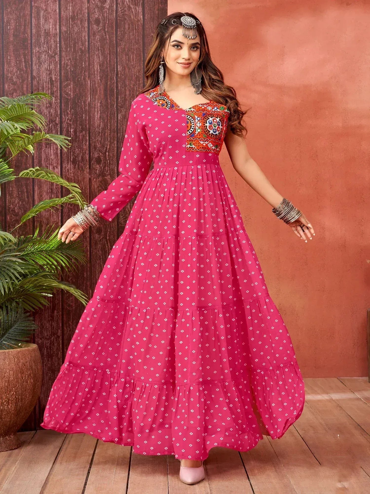 Pink ethnic gown with embroidered neckline and tiered skirt, perfect for Indian festive wear