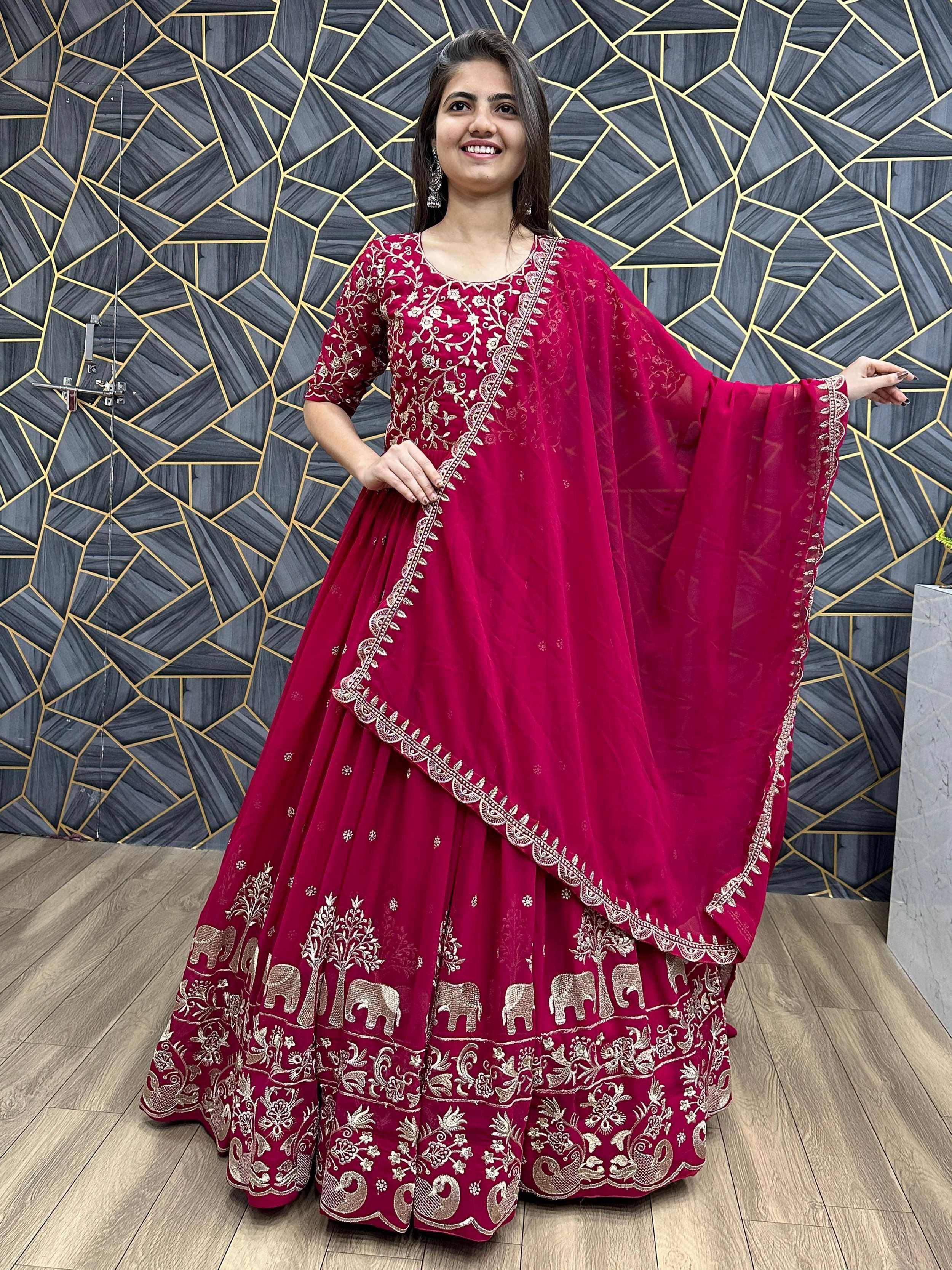 Woman in maroon embroidered lehenga choli with elephant motifs, perfect for Indian ethnic wear occasions.