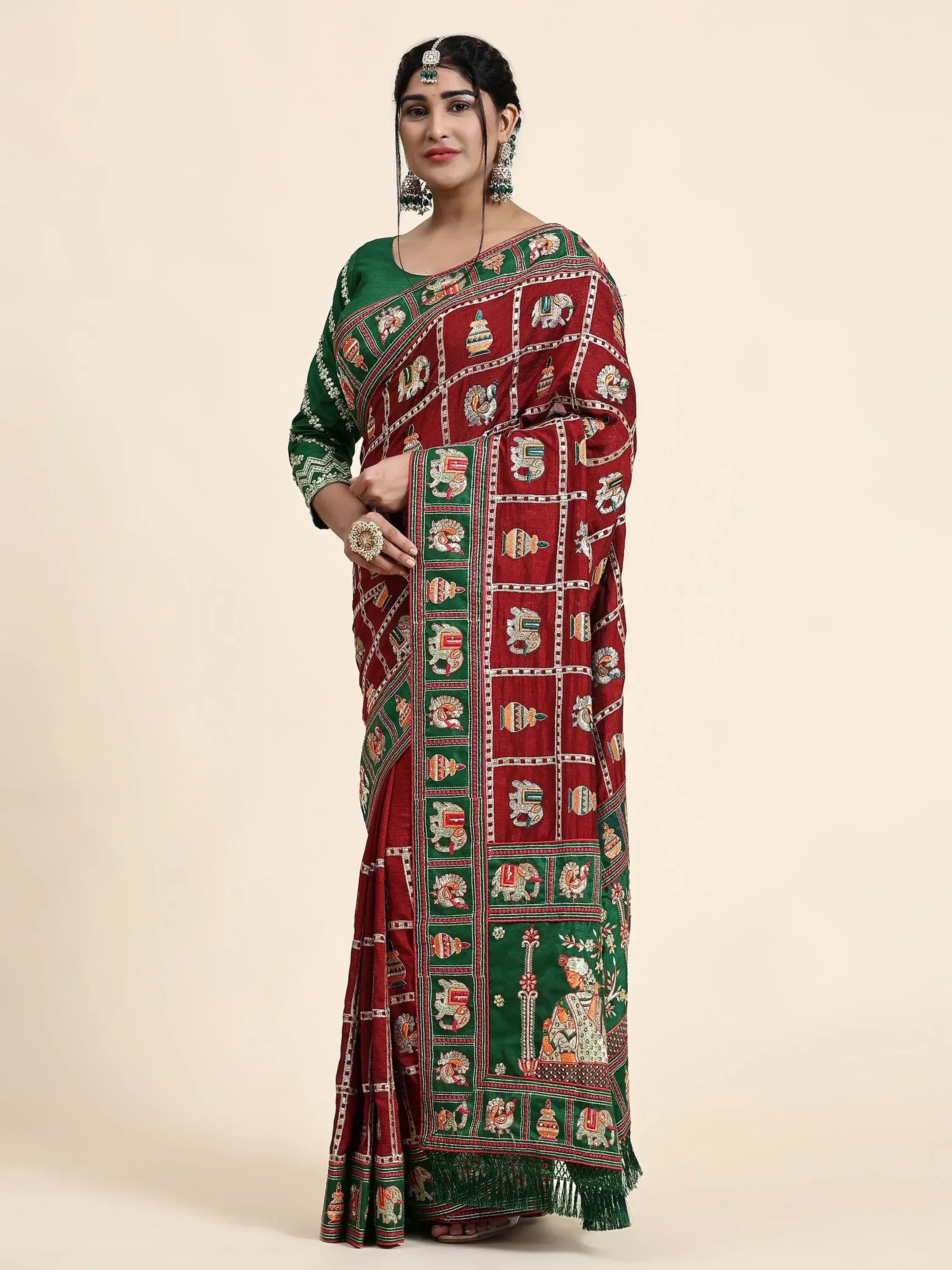 Woman in maroon and green embroidered saree with elephant motifs, traditional Indian ethnic wear