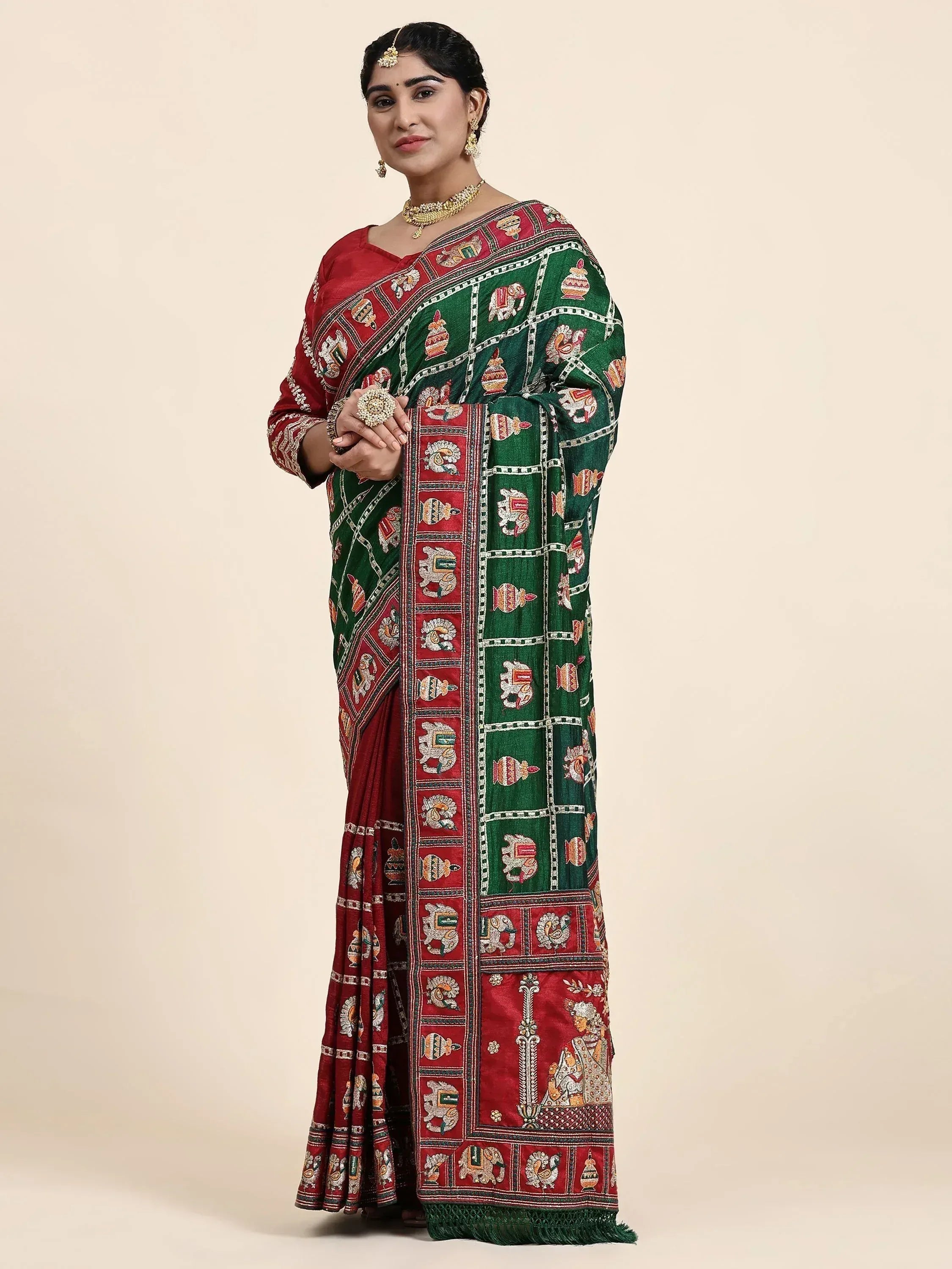 Woman in green and red embroidered saree with elephant motifs, traditional Indian ethnic wear