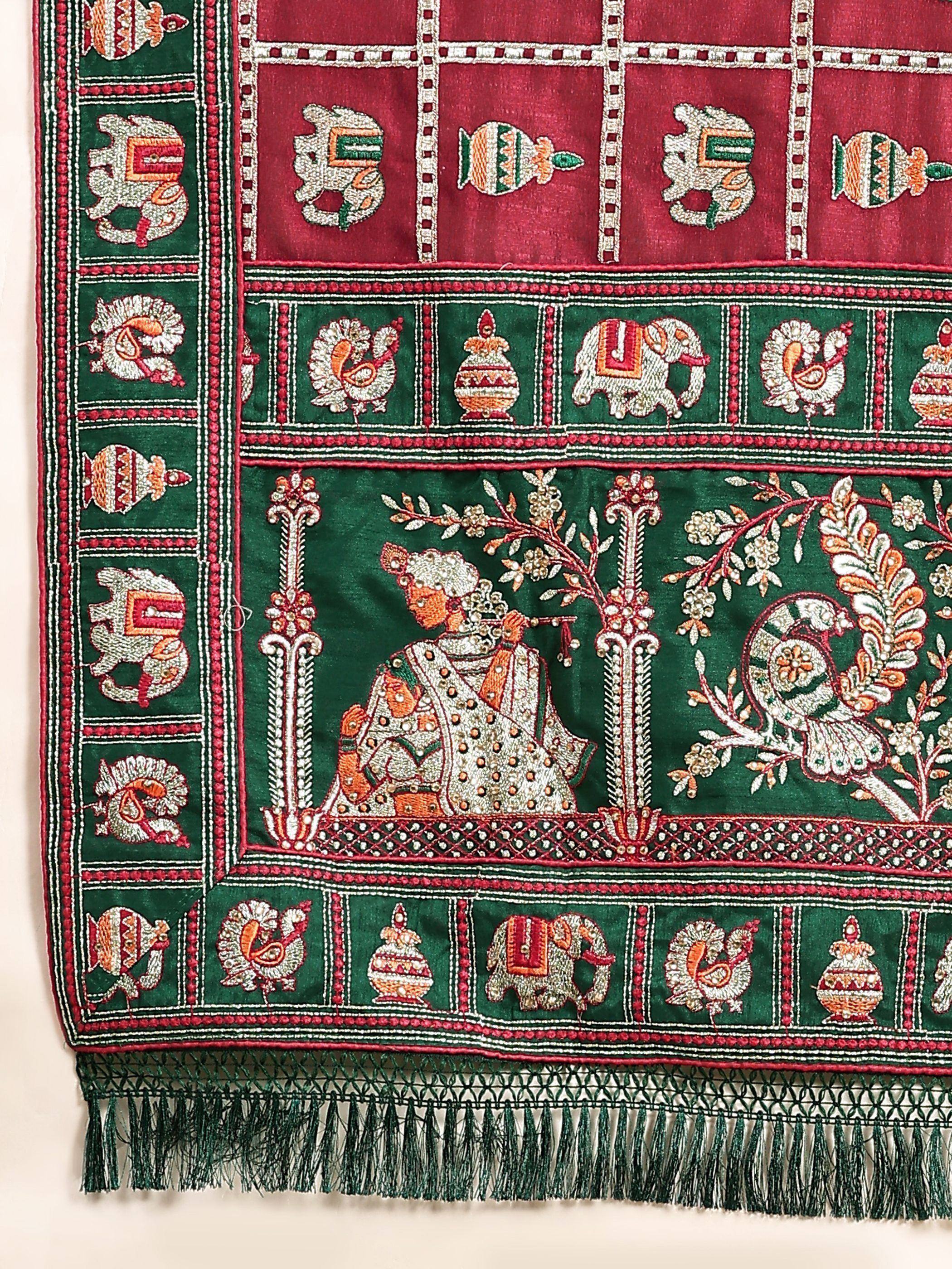 Richly embroidered Indian ethnic fabric with peacock, elephant, and flute player motifs in green and maroon