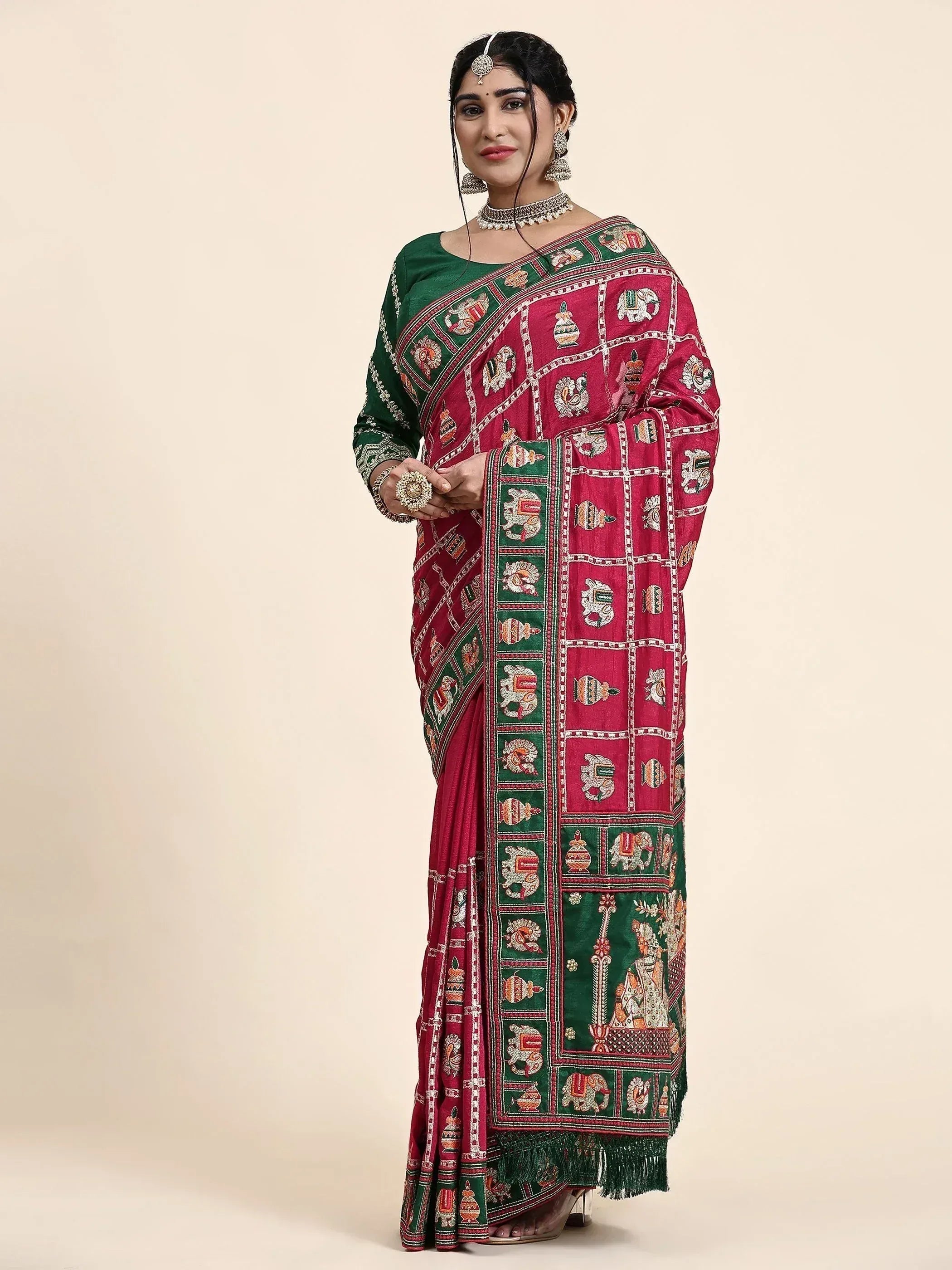 Woman in red and green embroidered saree with elephant motifs, traditional Indian ethnic wear