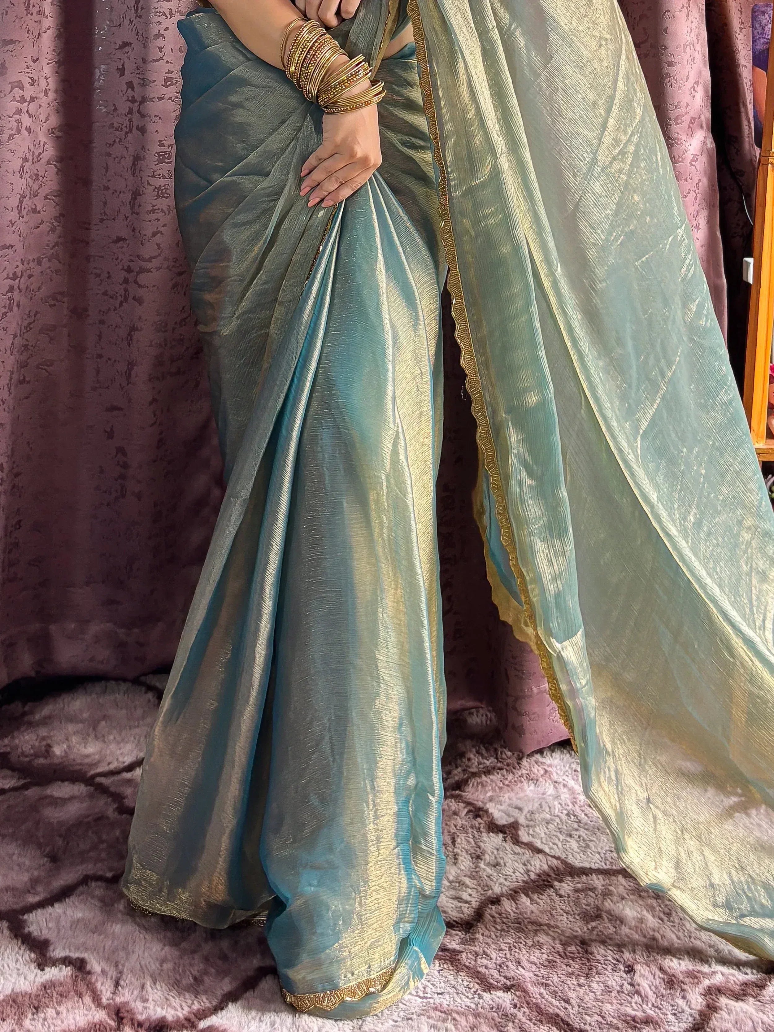 Teal and gold shimmer saree with intricate border, styled with traditional bangles for ethnic wear