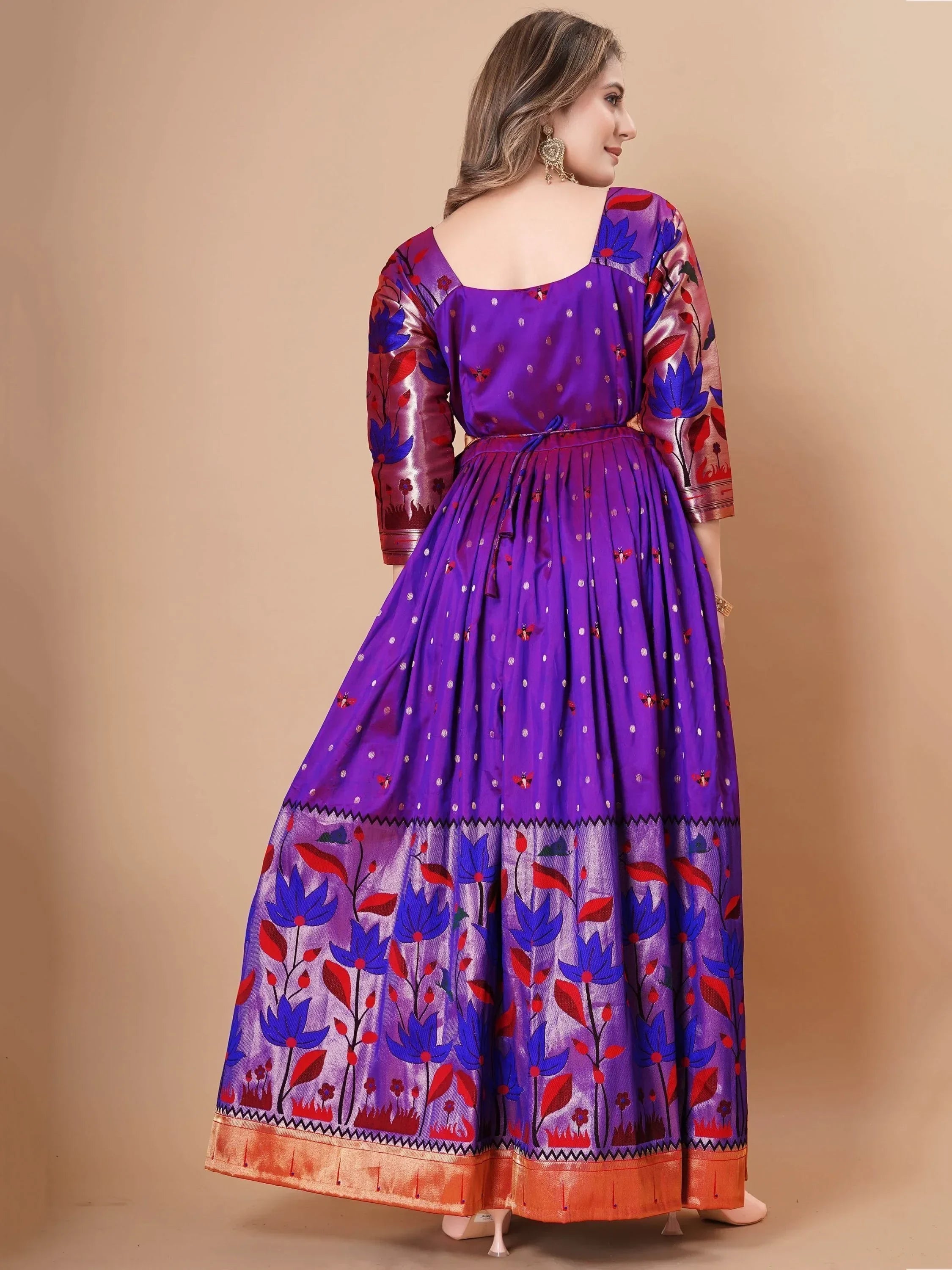 Woman wearing purple floral ethnic gown with gold border and three-quarter sleeves