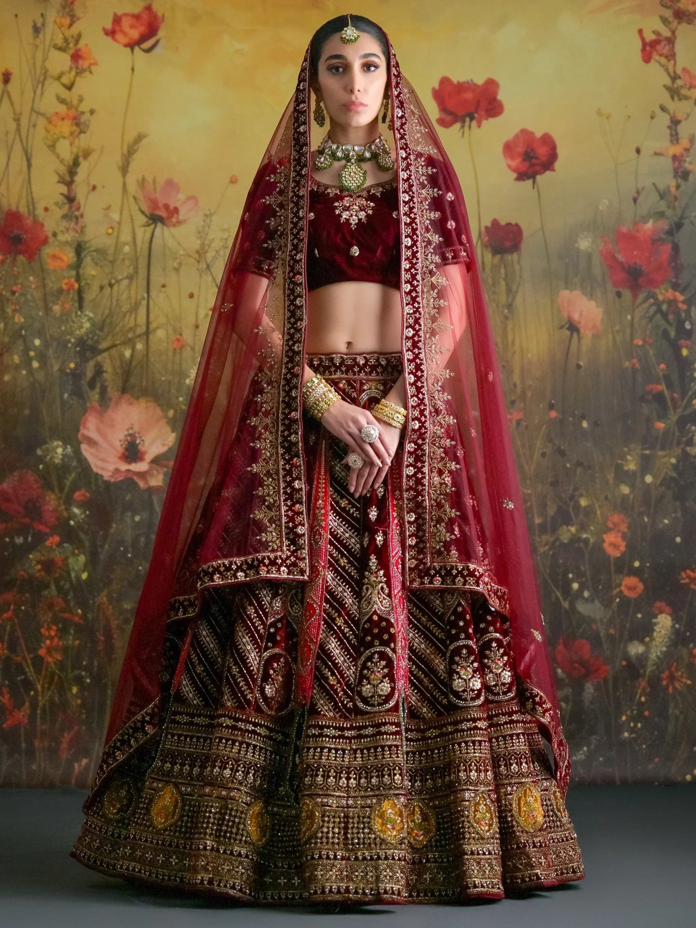 Maroon velvet designer lehenga choli with gold embroidery, perfect for Indian weddings and festive occasions.