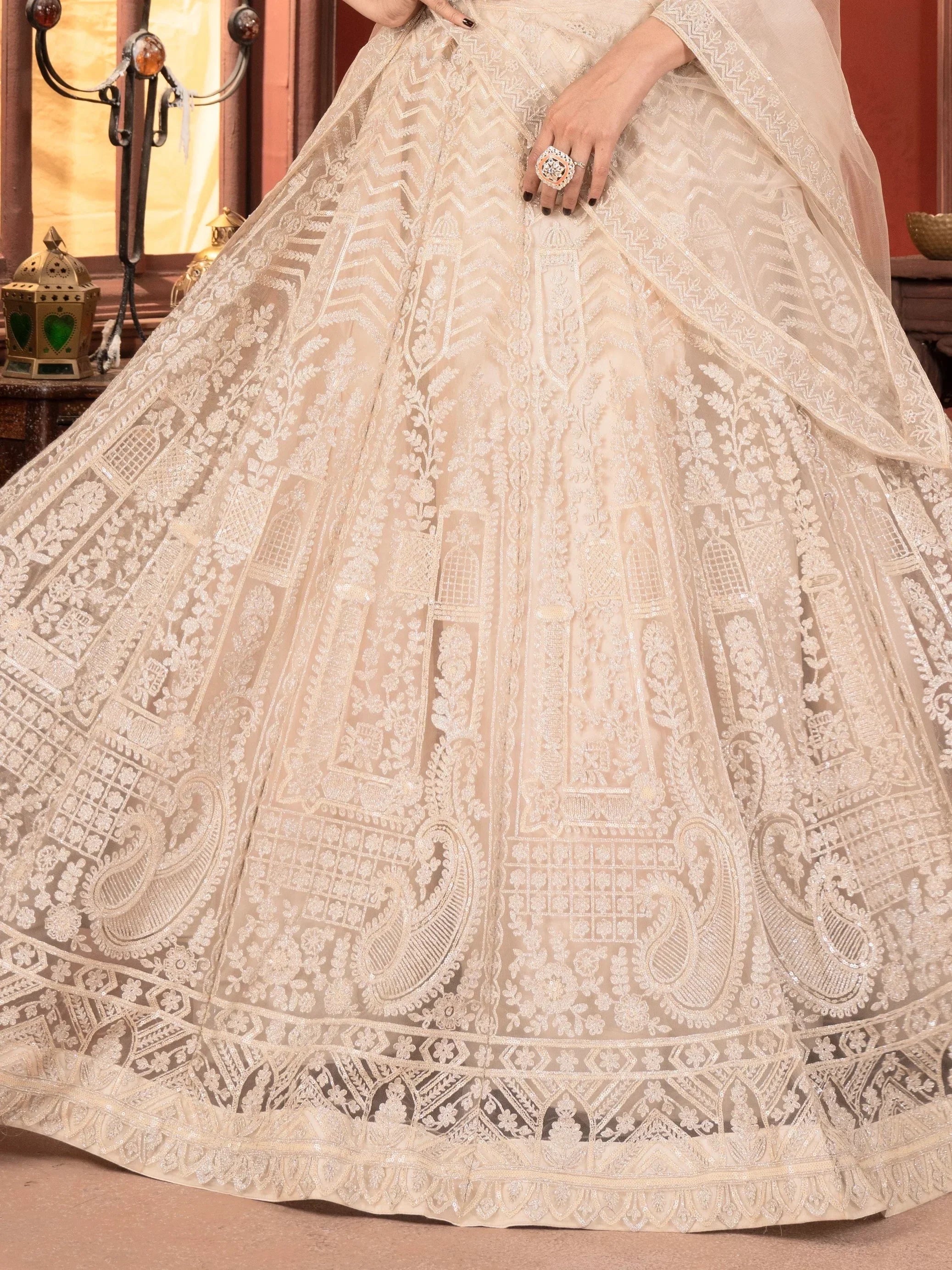 Cream designer lehenga with intricate floral and paisley embroidery, perfect for Indian weddings and festive occasions.