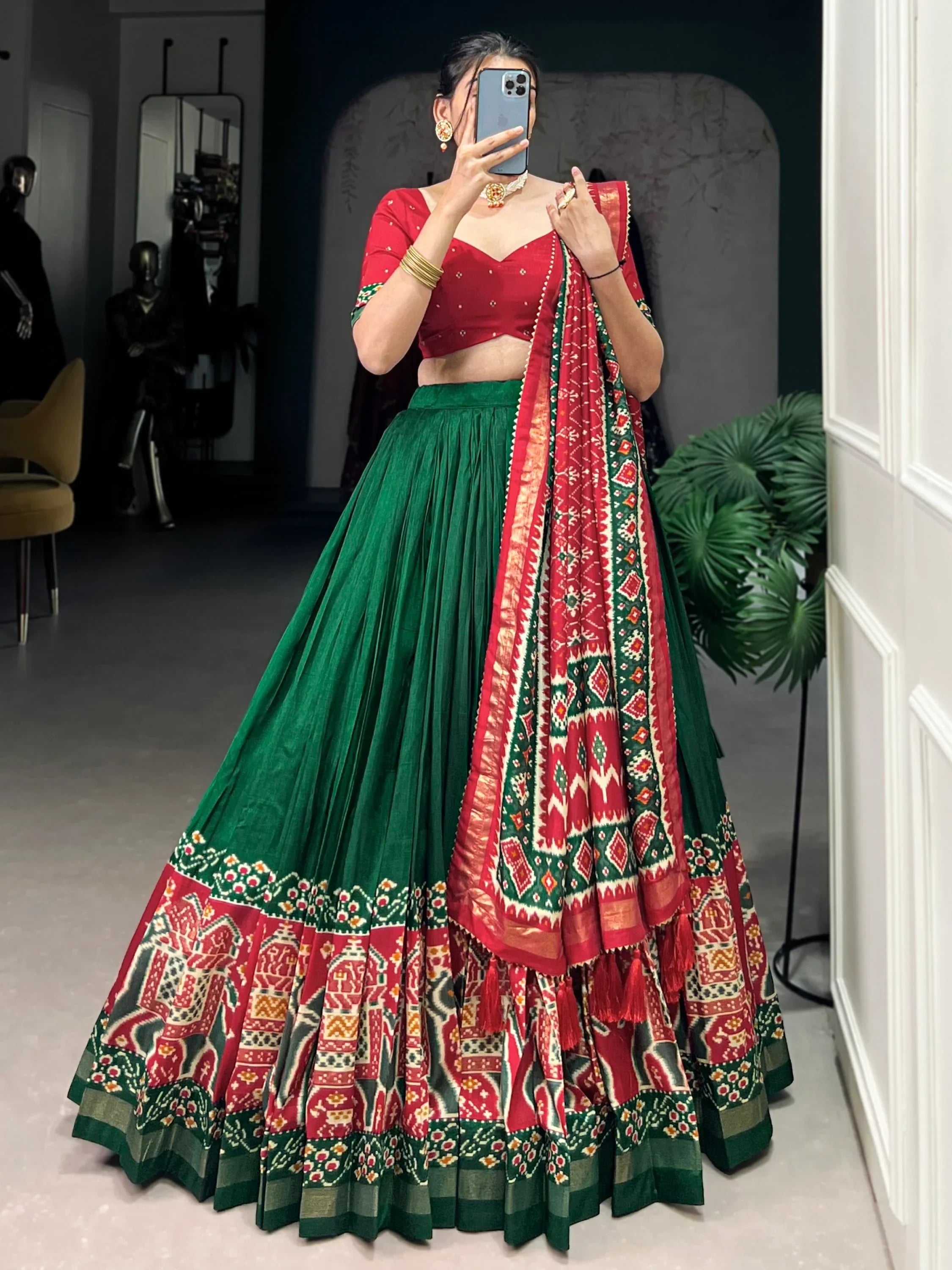 Red and green designer lehenga choli with intricate ikat patterns, perfect for Indian ethnic wear occasions.
