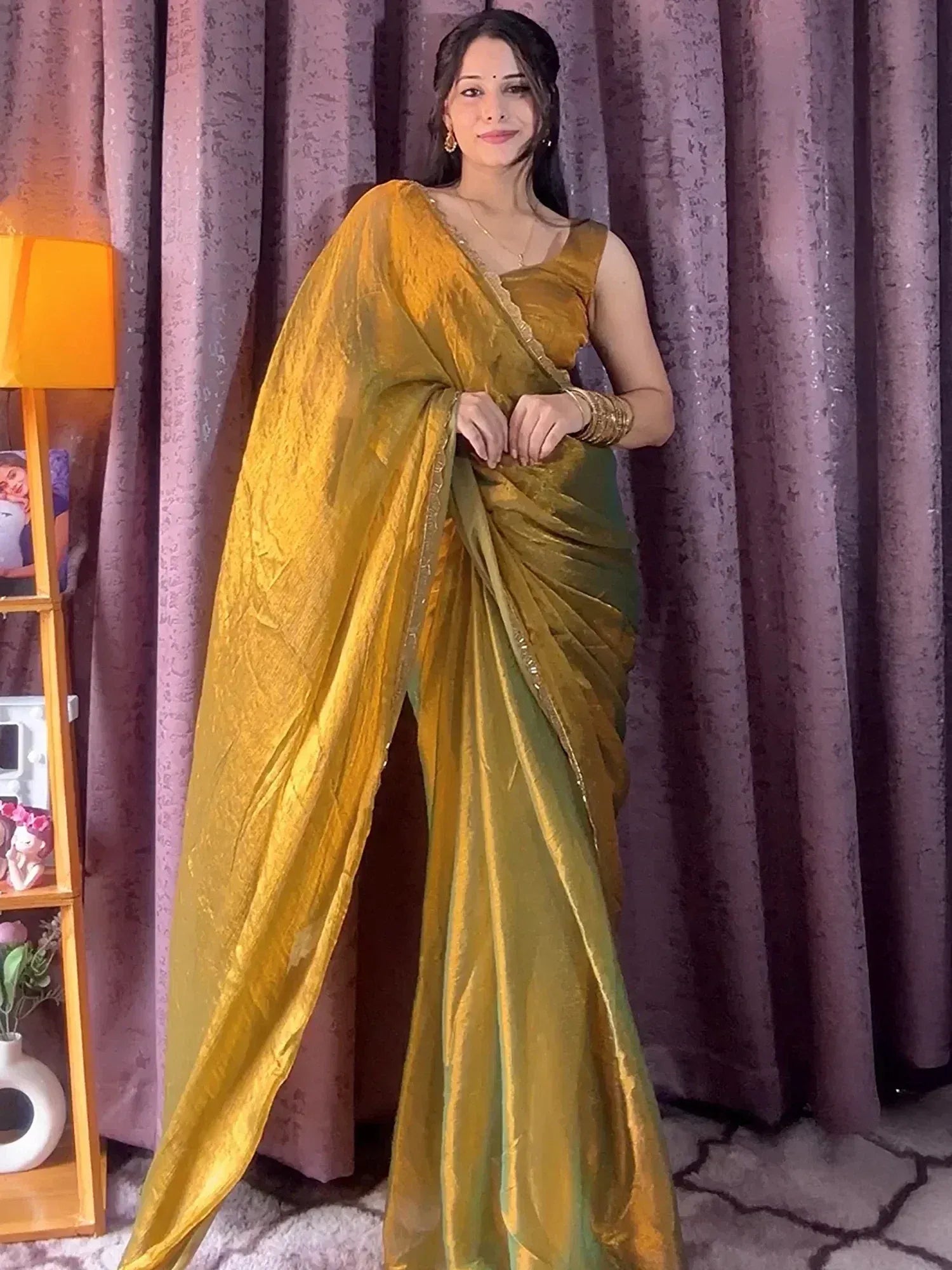 Woman in elegant golden yellow saree with shimmering texture, perfect for Indian ethnic occasions.