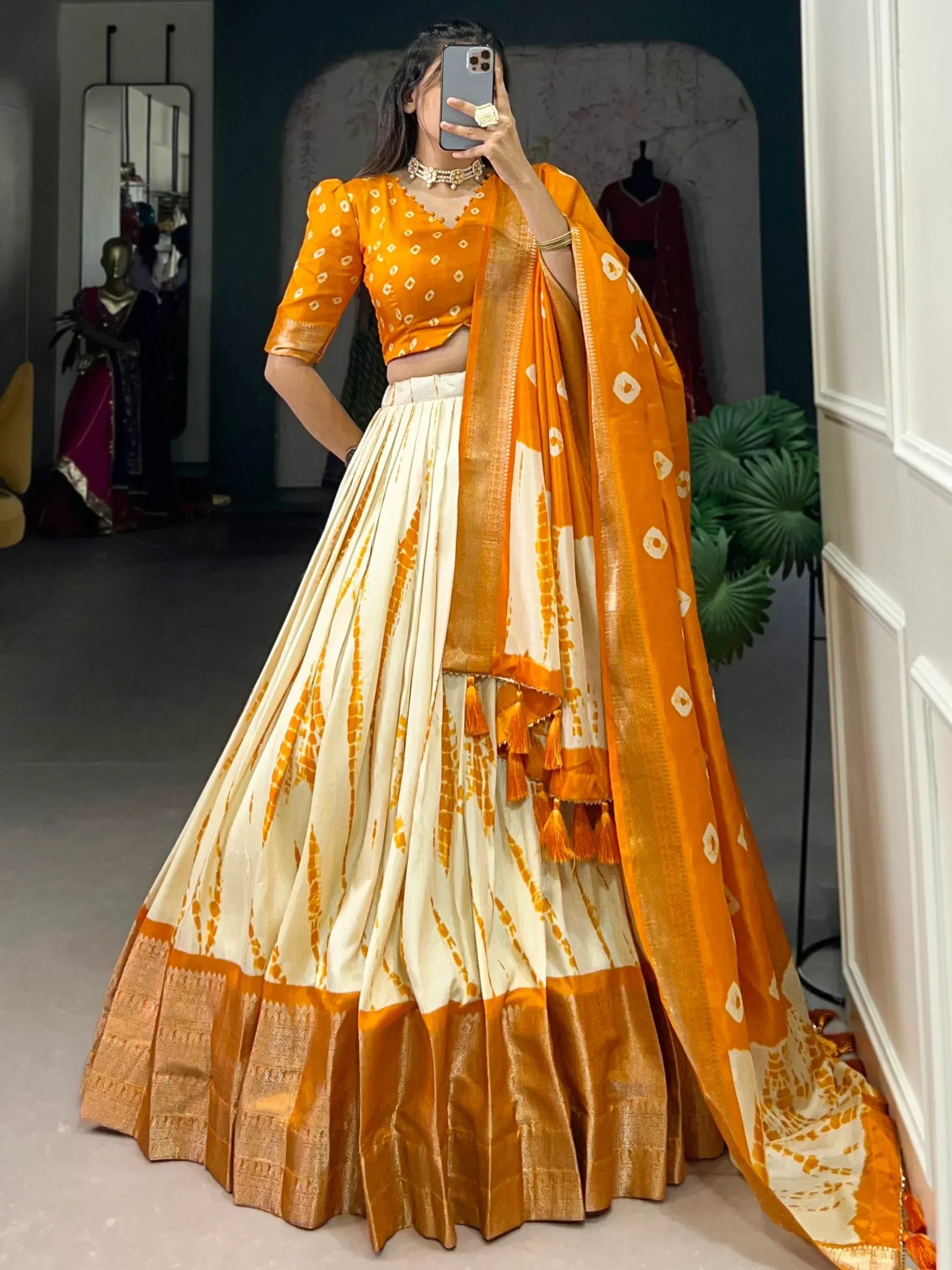 Orange and cream designer lehenga choli with tie-dye print and tassels, perfect for Indian ethnic wear.