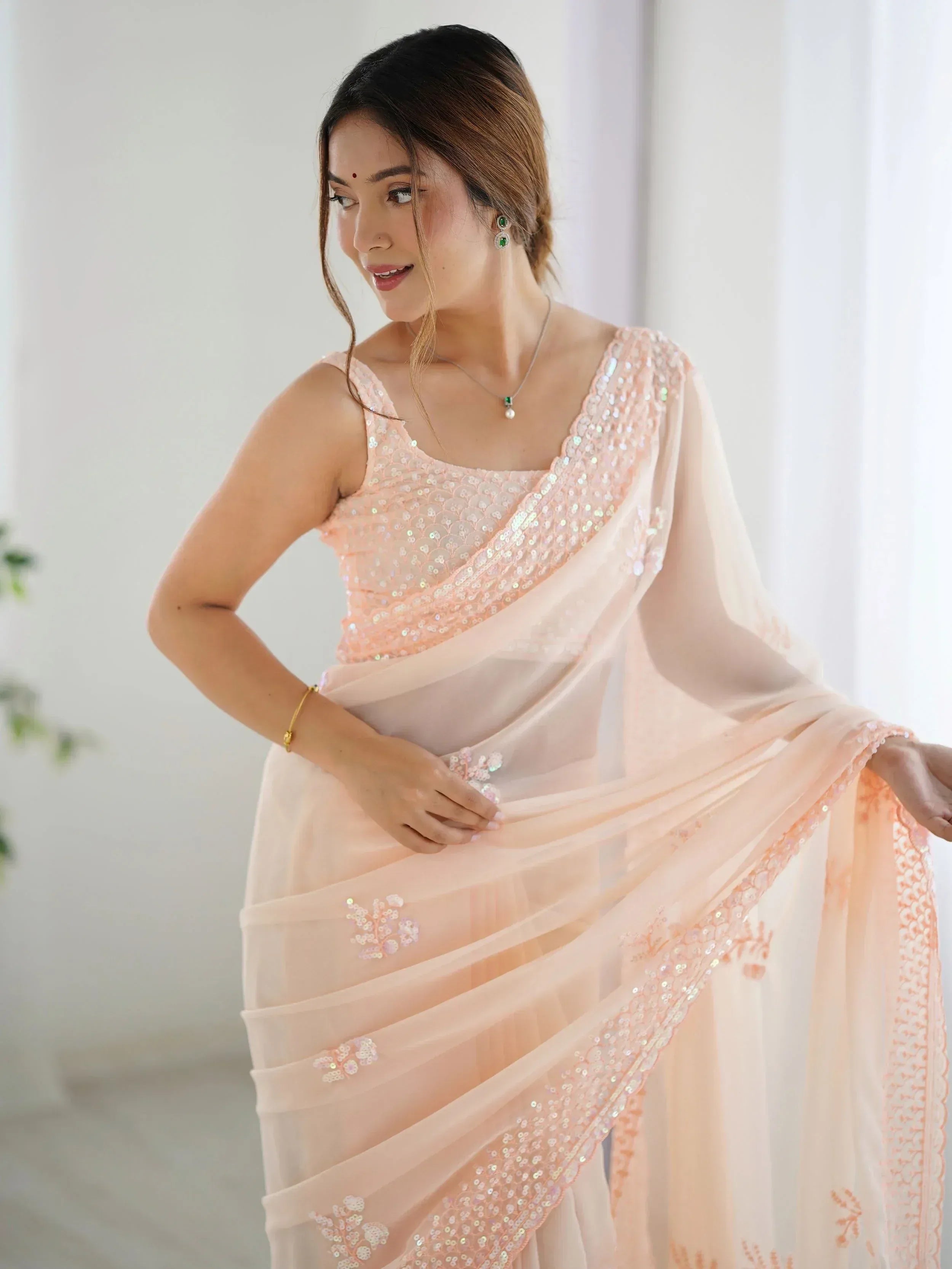 Elegant peach saree with sequin work, perfect for Indian ethnic occasions and festive wear.