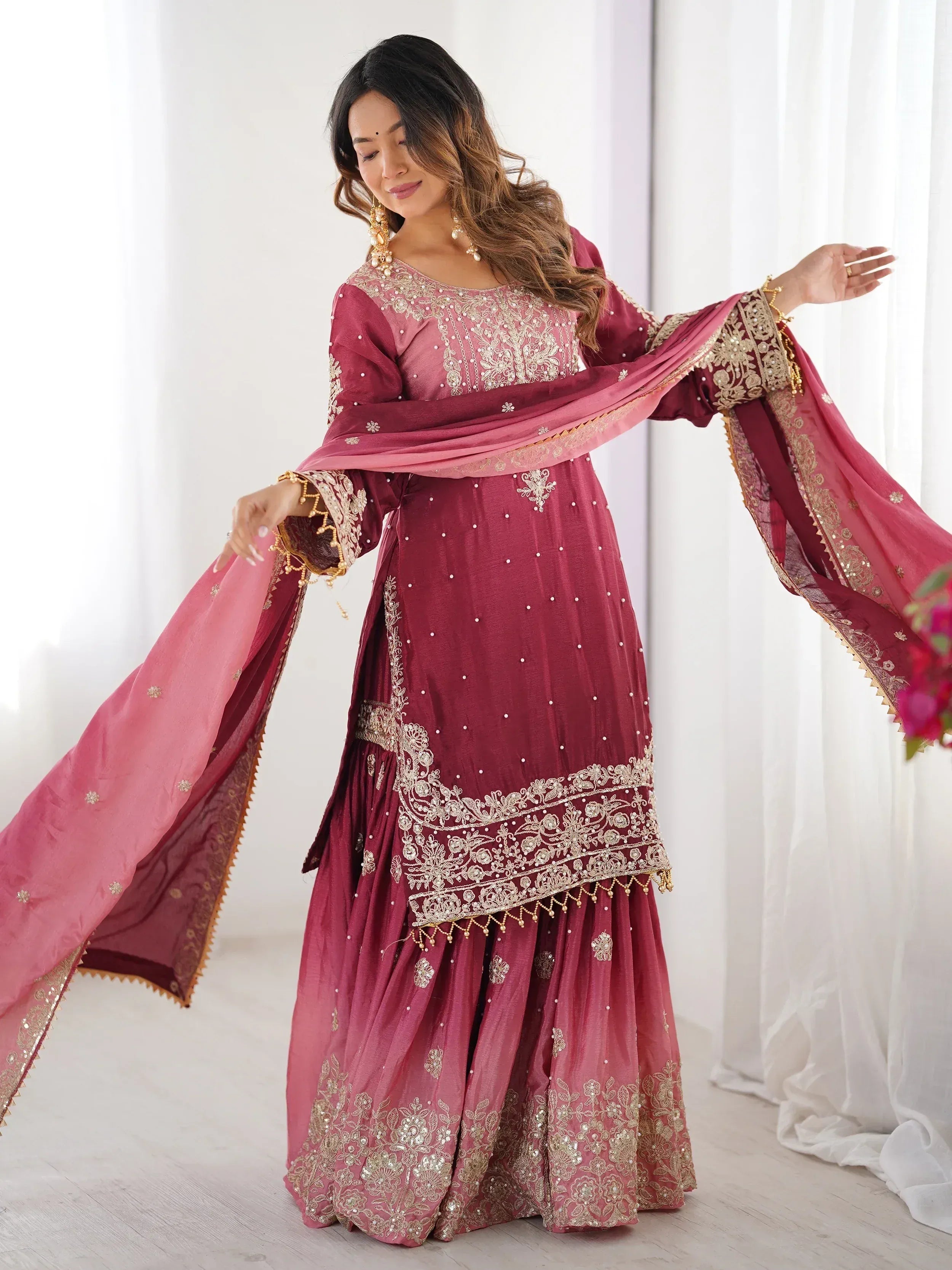 Elegant maroon ethnic gown with gold embroidery and matching dupatta, perfect for Indian celebrations.