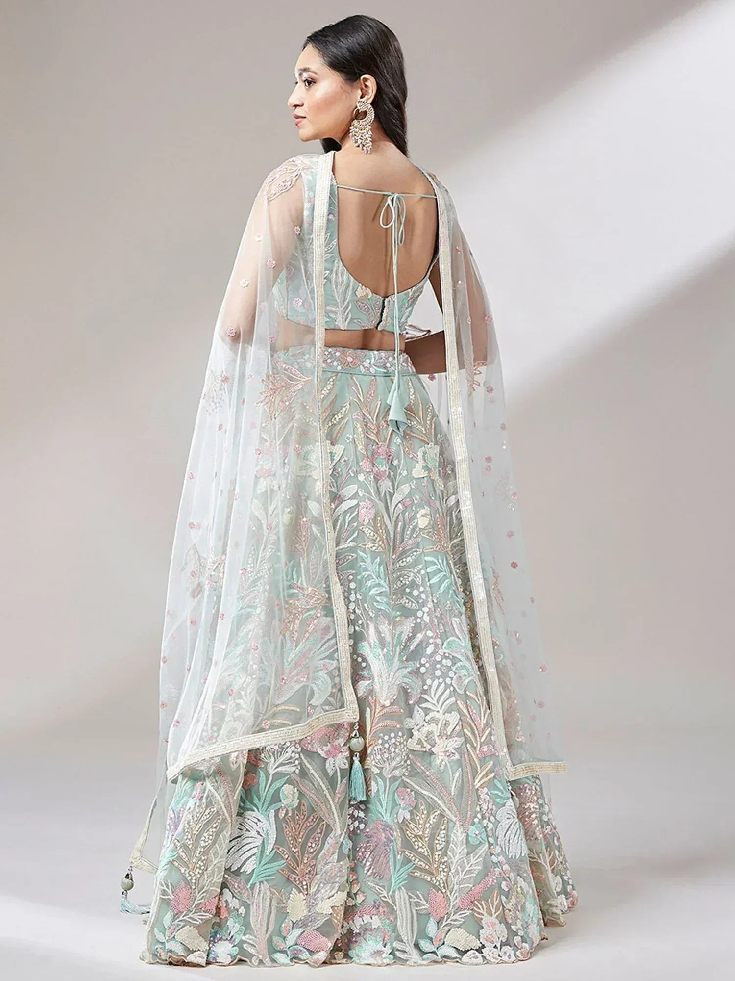 Mint green embroidered lehenga choli with floral motifs and sheer dupatta, perfect for Indian weddings or festive occasions.