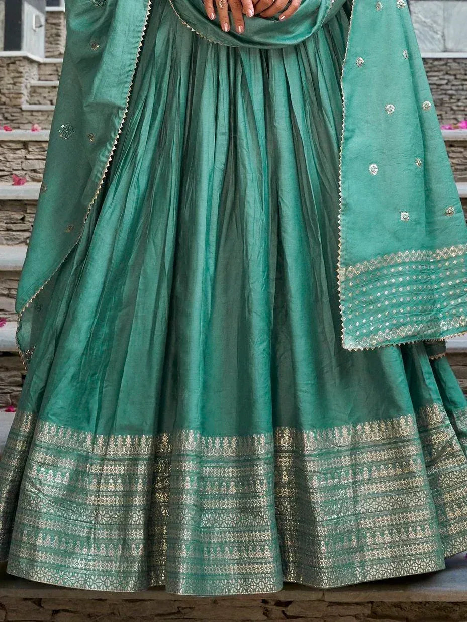 Emerald green designer lehenga choli with gold zari border and embroidered dupatta, perfect for Indian ethnic wear.