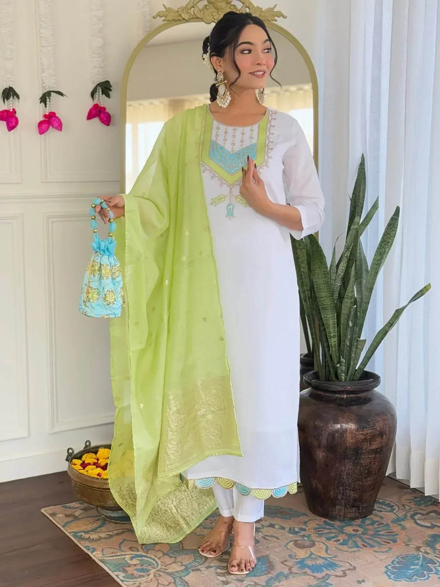 Elegant white salwar kameez with lime dupatta, turquoise embroidery, and matching potli bag for festive occasions.
