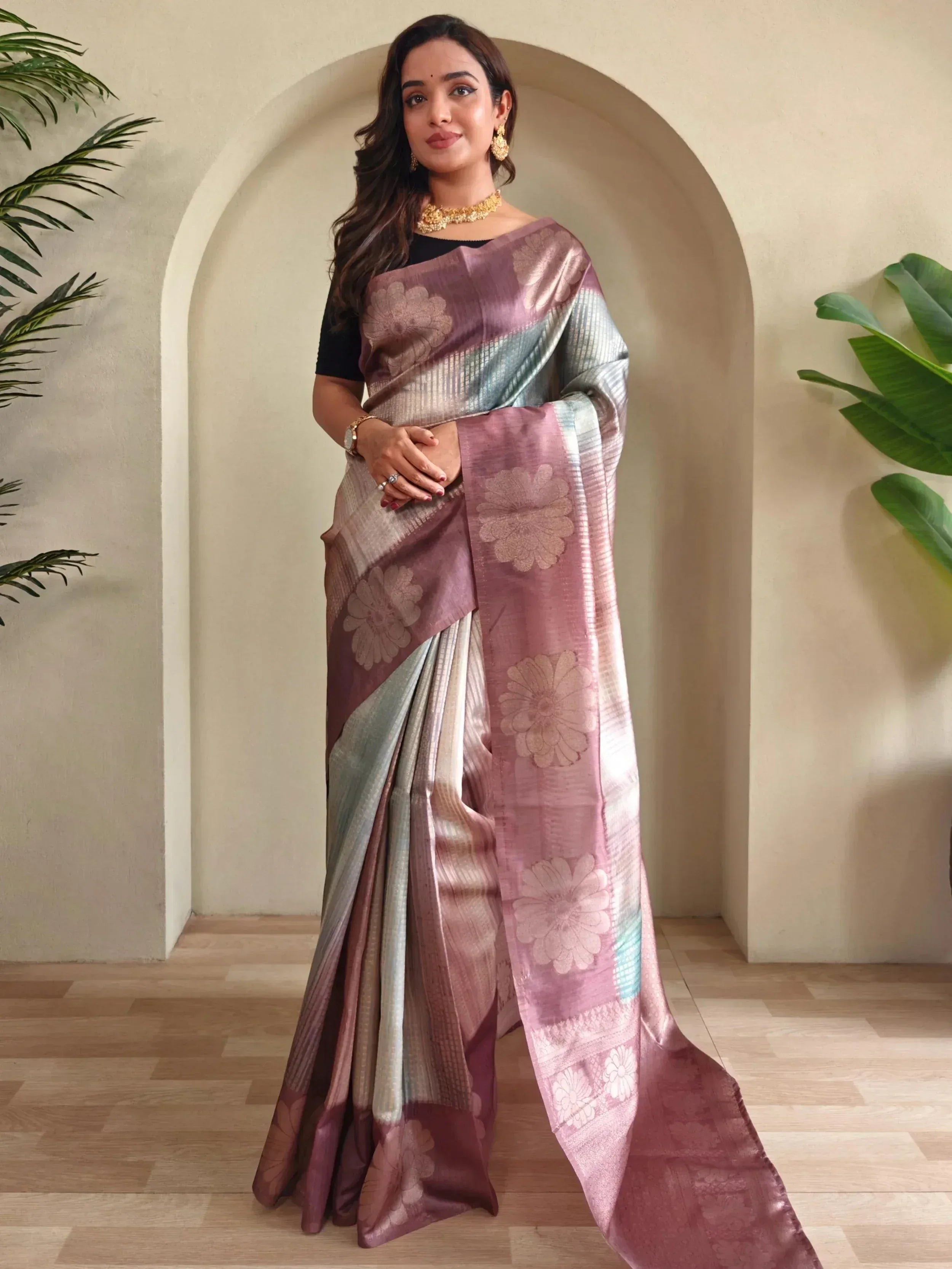 Woman in elegant pink and silver floral saree with gold jewelry, styled for Indian ethnic wear