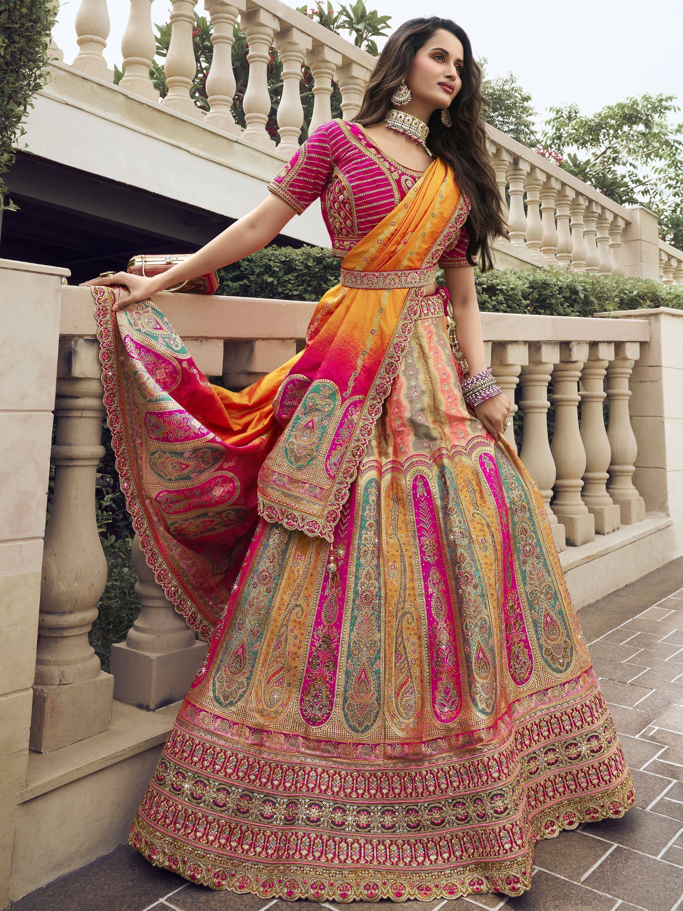Vibrant pink and gold embroidered lehenga choli with intricate paisley patterns, perfect for Indian weddings and festive occasions.