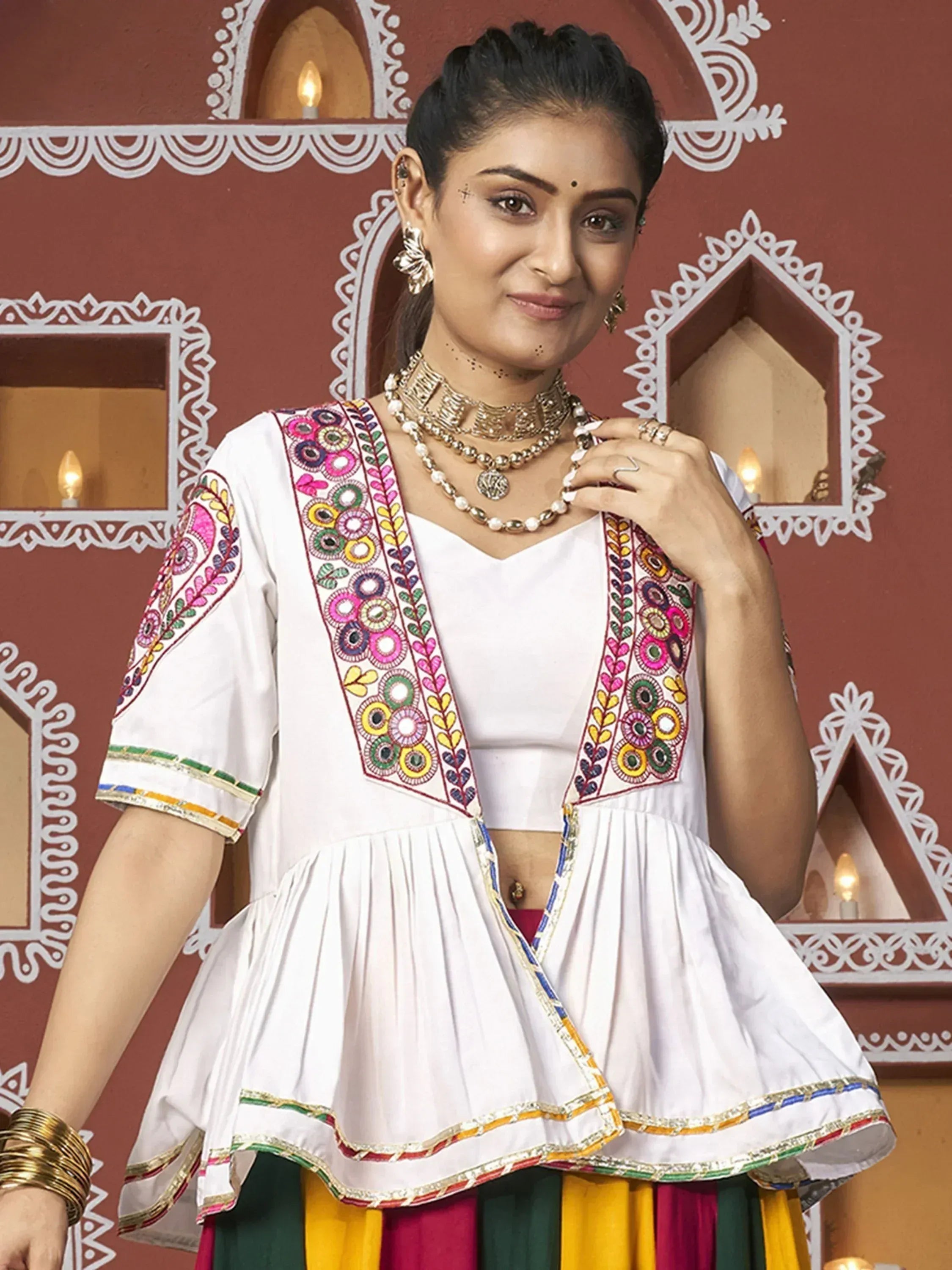 White embroidered ethnic top with colorful mirror work, paired with vibrant skirt, traditional Indian wear