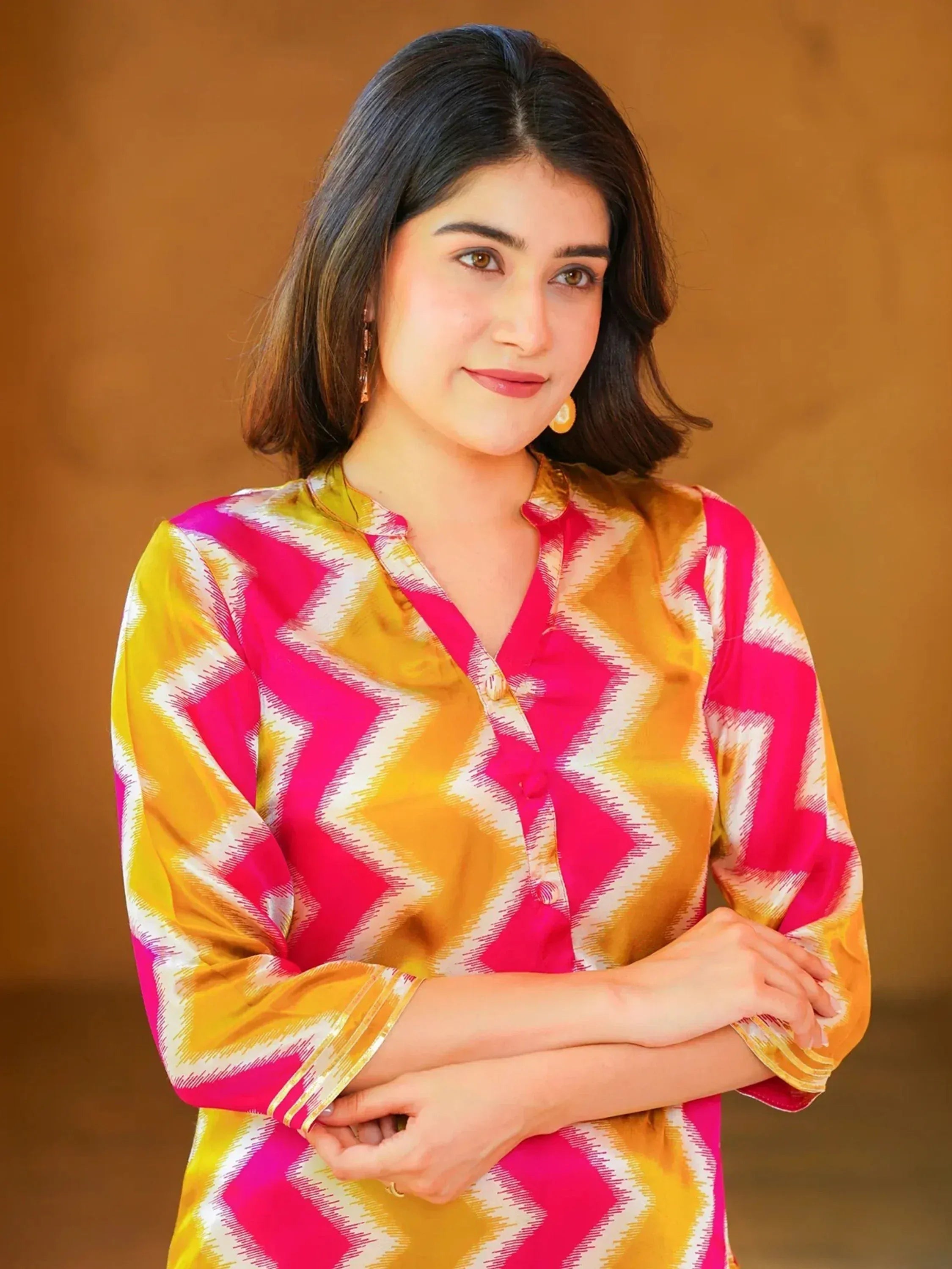 Woman in vibrant pink and yellow ethnic kurti with geometric print, perfect for Indian wear
