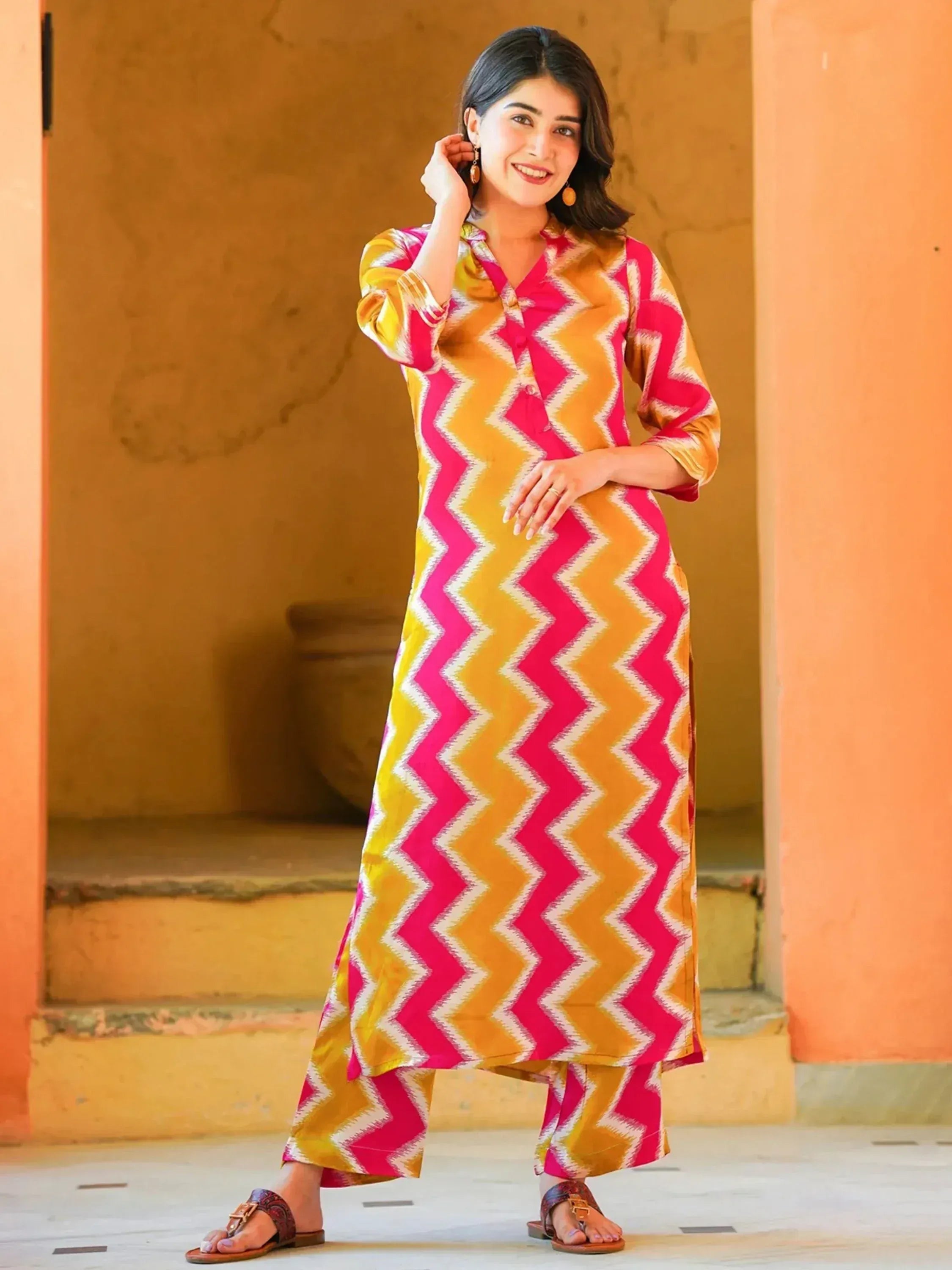 Woman in vibrant pink and yellow zigzag print salwar kameez, ethnic Indian wear