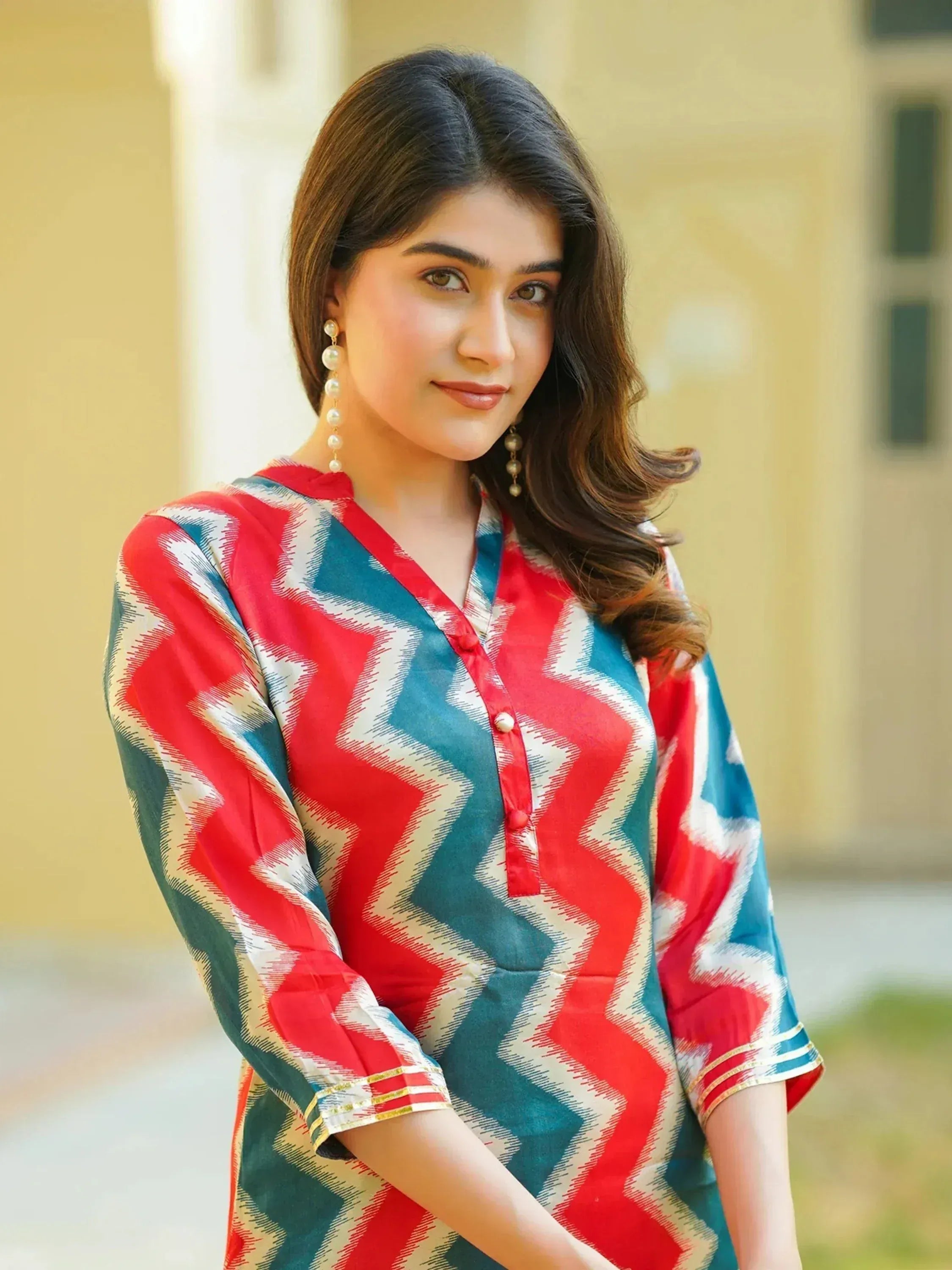 Woman in red and blue chevron print ethnic kurti with pearl earrings