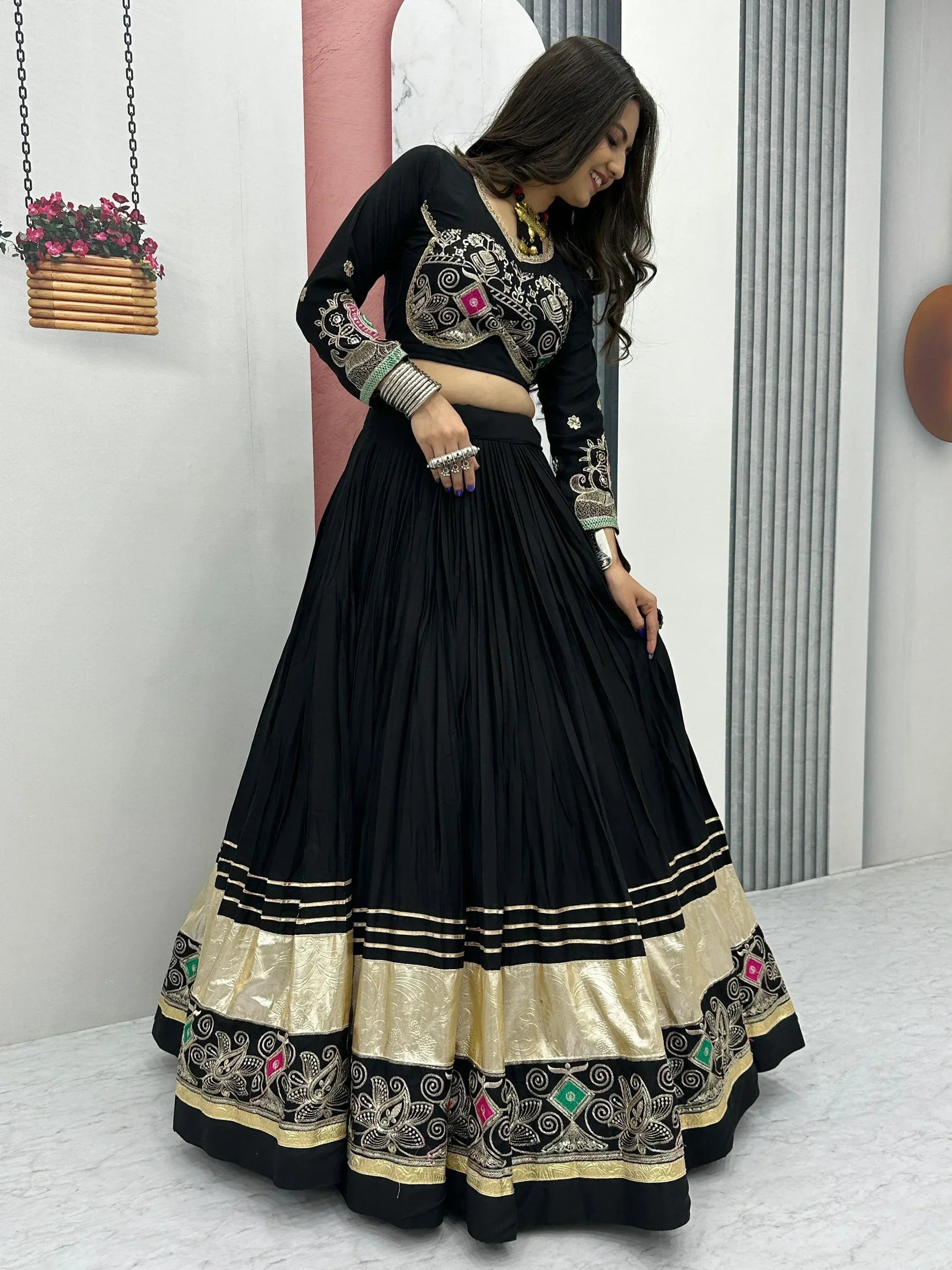 Black embroidered lehenga choli with gold and colorful detailing, perfect for Indian ethnic wear occasions.