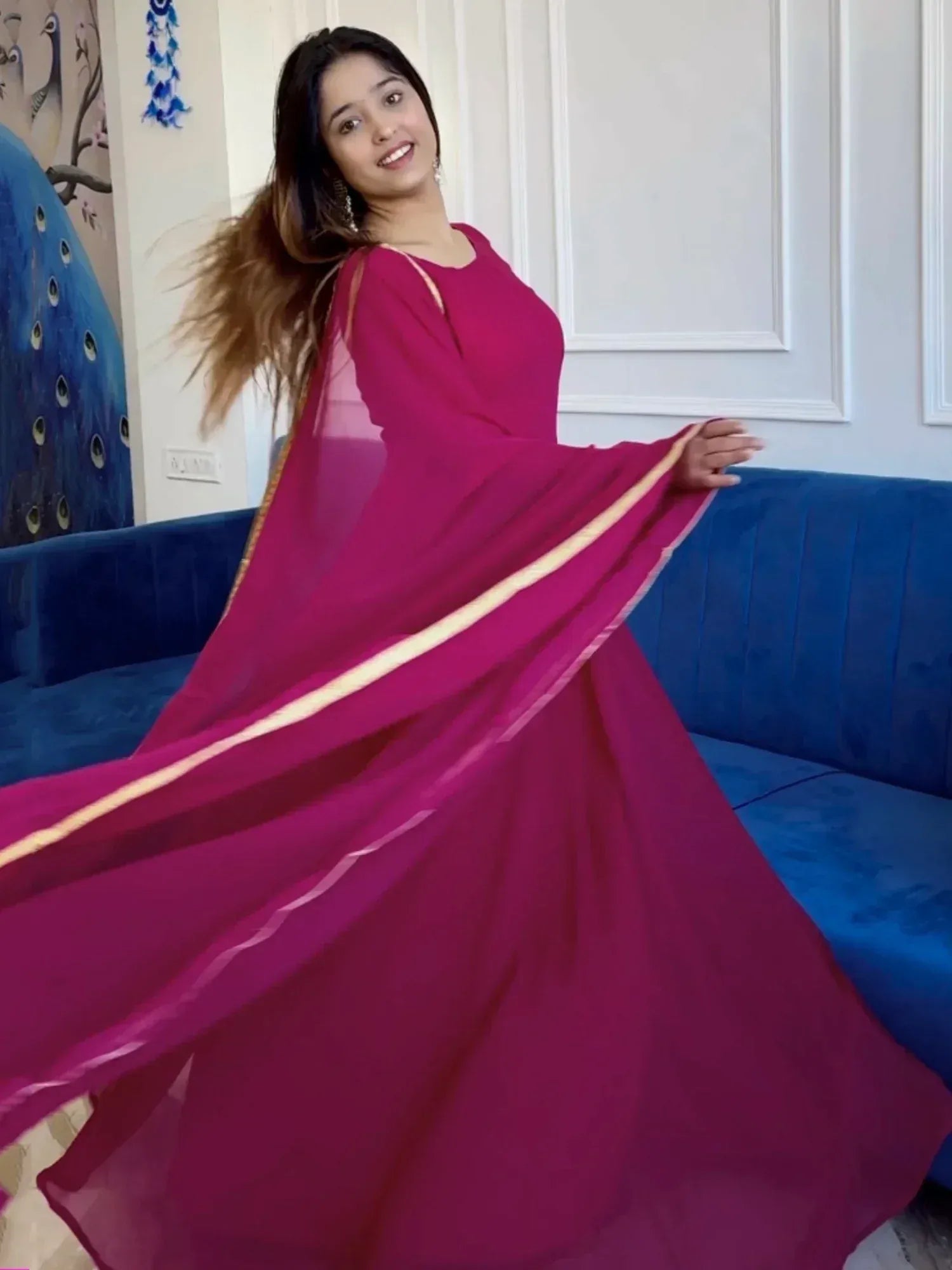 Woman in flowing magenta ethnic gown with gold trim, styled for festive occasions