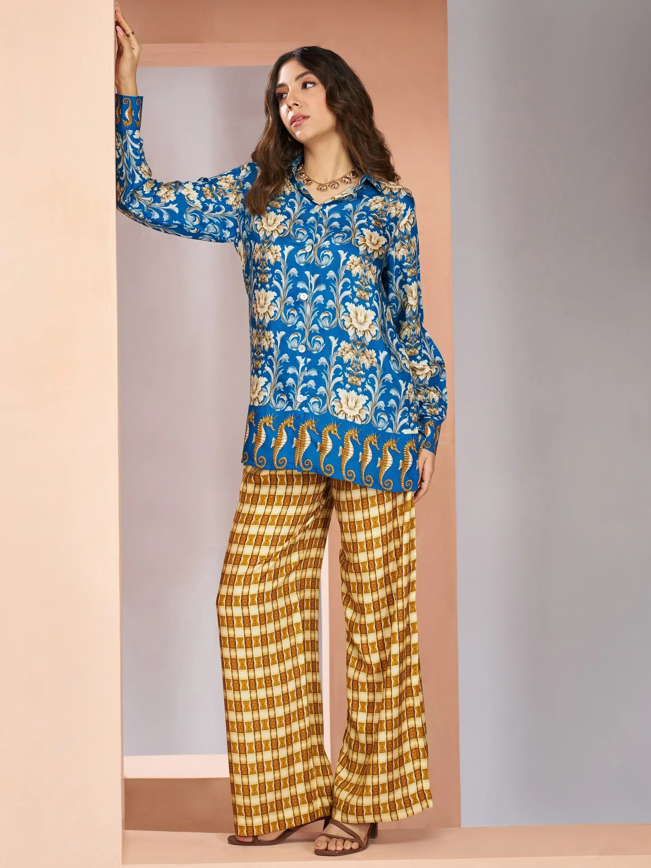 Blue floral printed kurta with seahorse hem paired with gold checkered palazzo pants, ethnic wear
