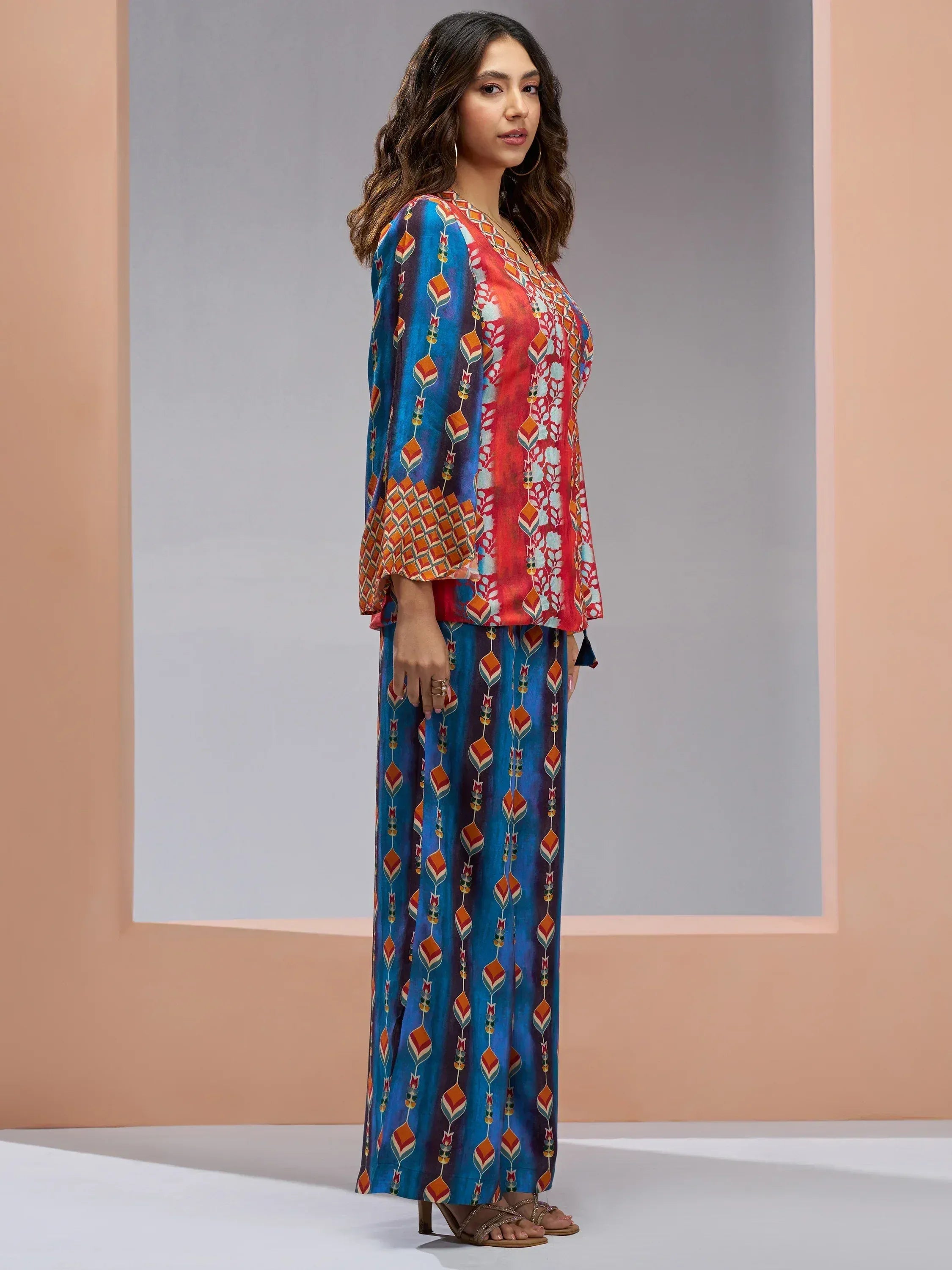 Woman in colorful printed ethnic palazzo set with blue and red floral patterns, stylish Indian wear