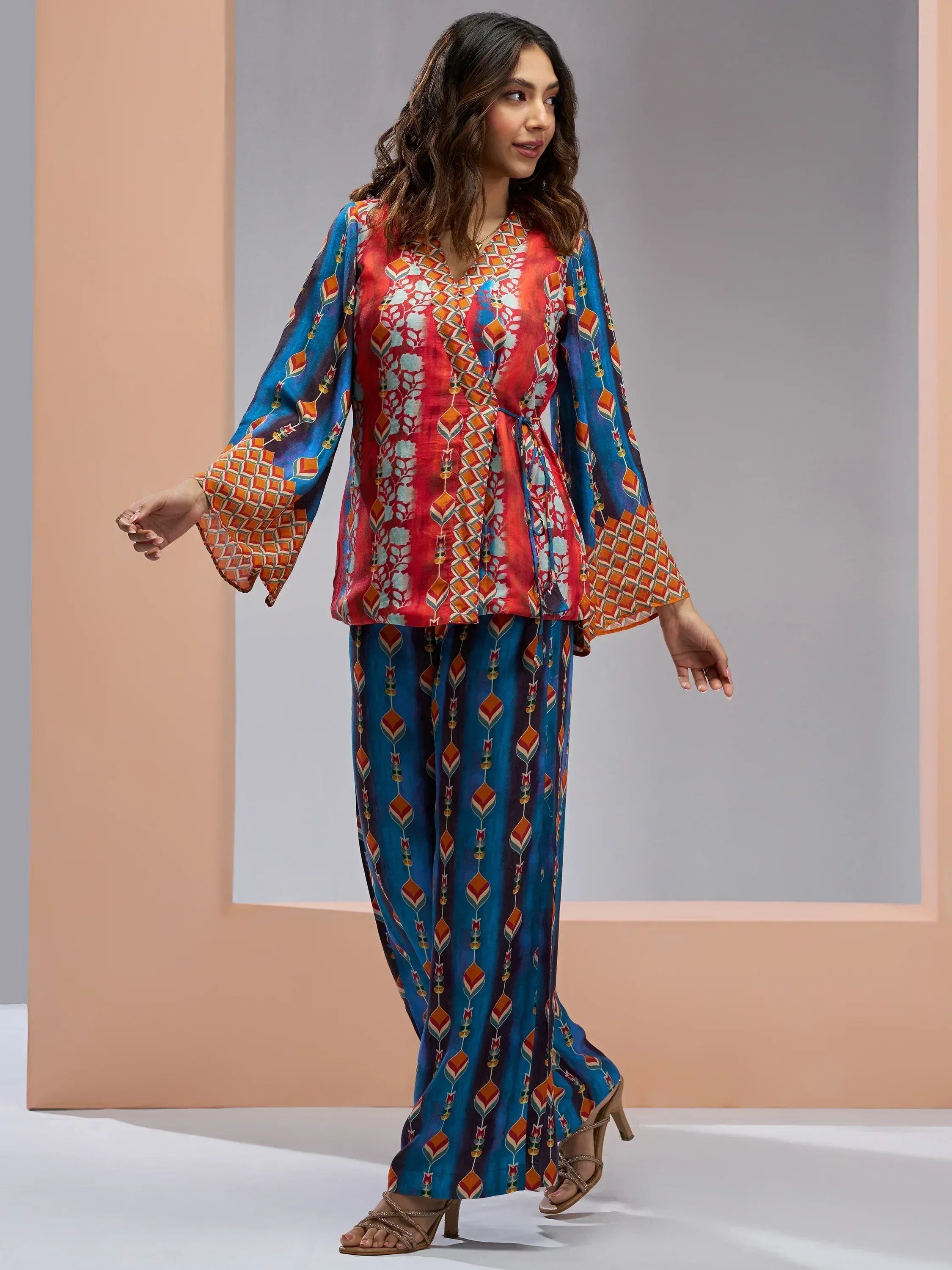 Woman in vibrant printed ethnic salwar kameez with flared sleeves and palazzo pants, perfect for Indian festive wear.