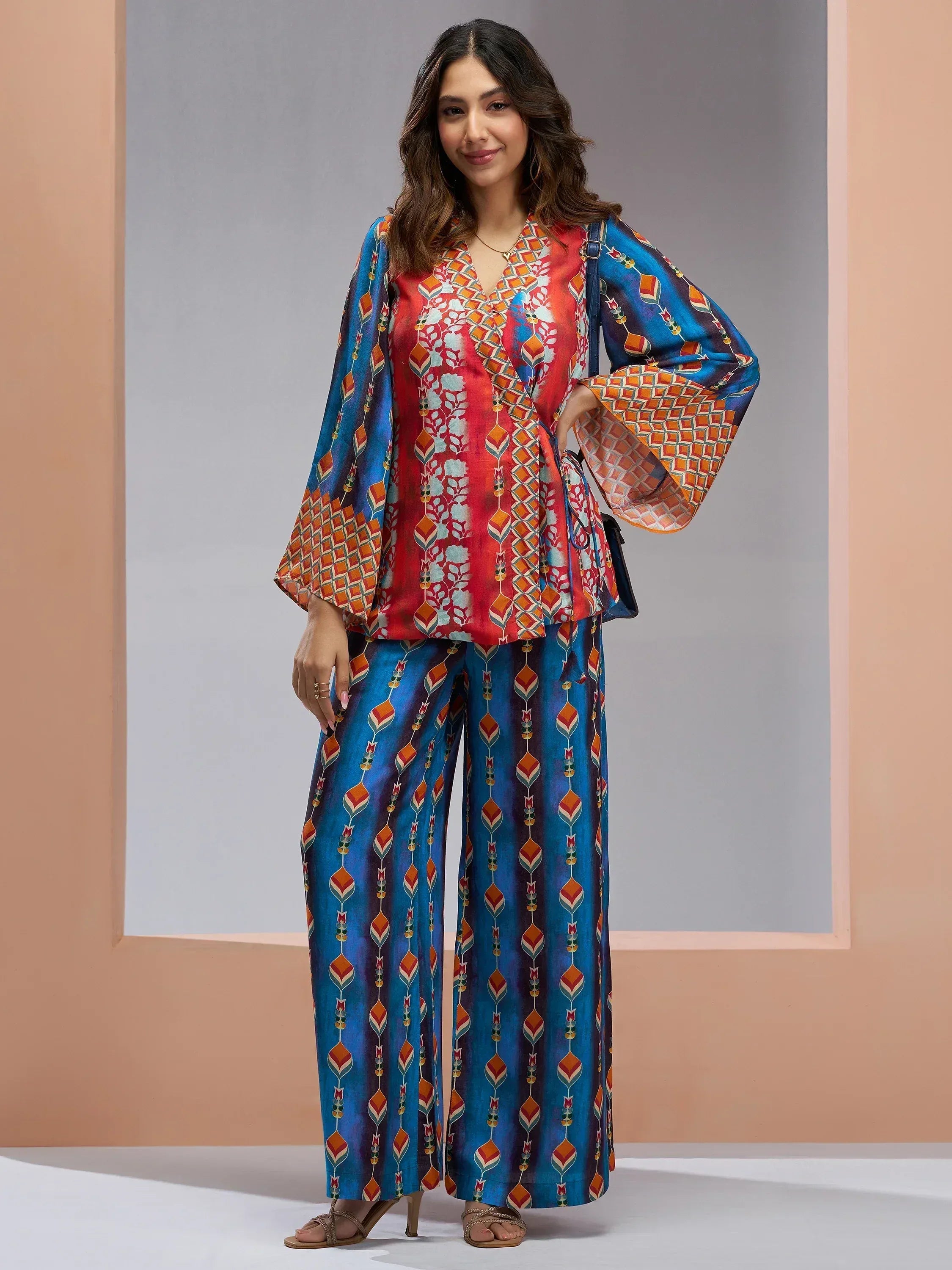 Woman in vibrant printed ethnic palazzo suit with wide sleeves, perfect for Indian festive occasions