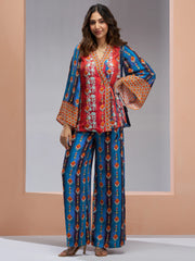 Woman in colorful printed ethnic co-ord set from Ethnic Plus standing against a peach backdrop