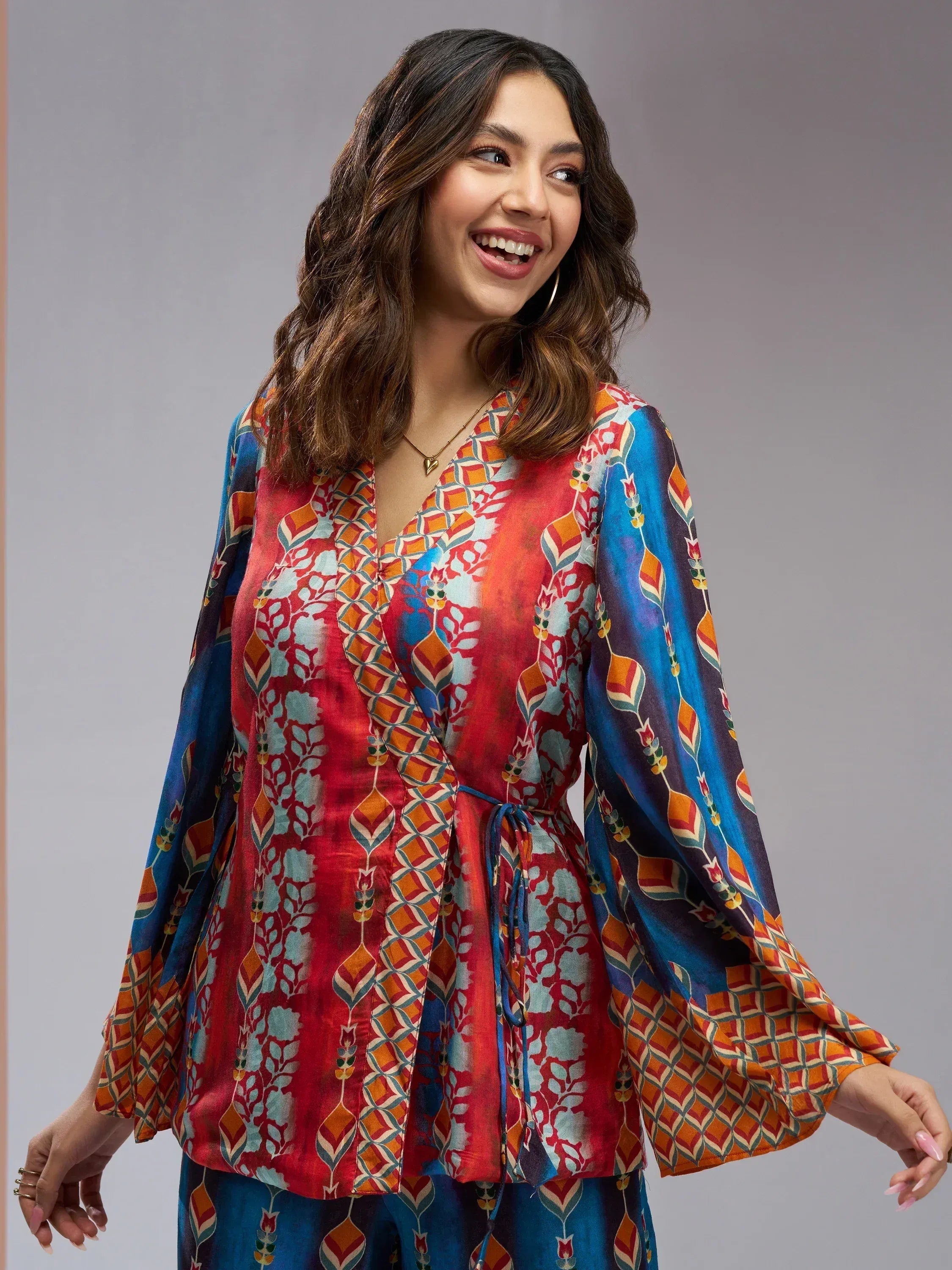 Woman in vibrant printed ethnic gown with bell sleeves, perfect for Indian festive occasions