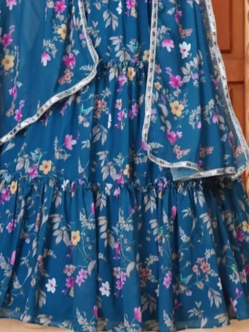 Blue floral print ethnic gown with ruffled layers and silver trim, perfect for Indian occasions