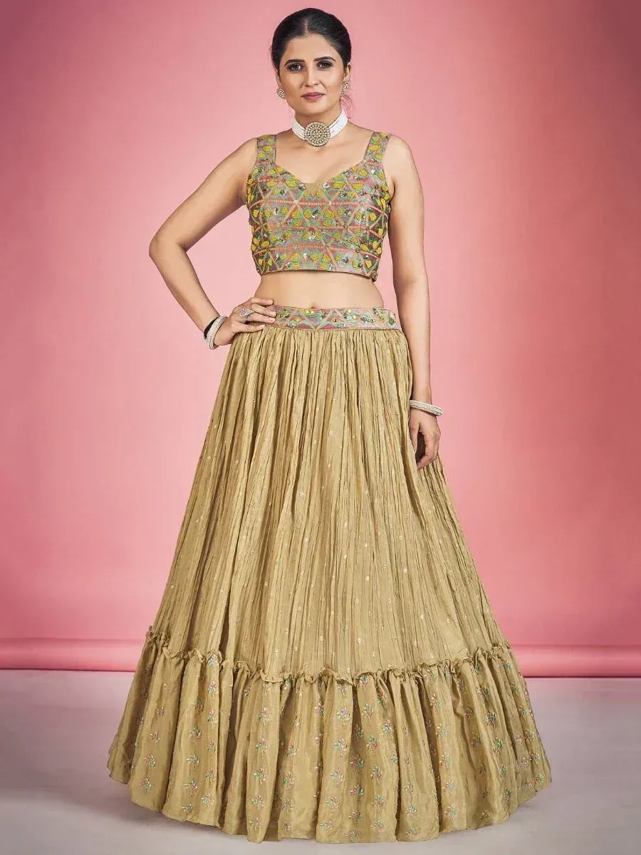 Woman in gold embroidered lehenga choli with floral motifs, perfect for Indian ethnic wear occasions