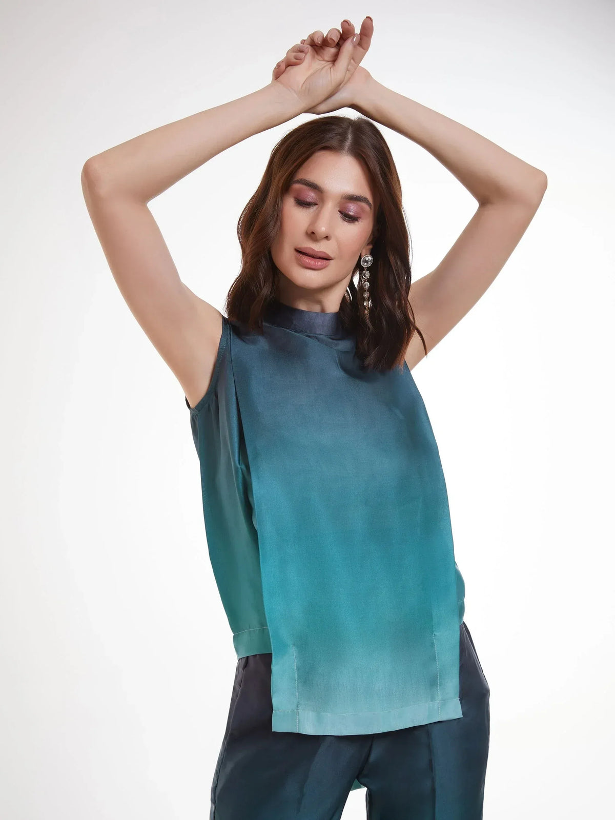 Teal sleeveless ethnic top with high neck, paired with matching pants for modern Indian wear