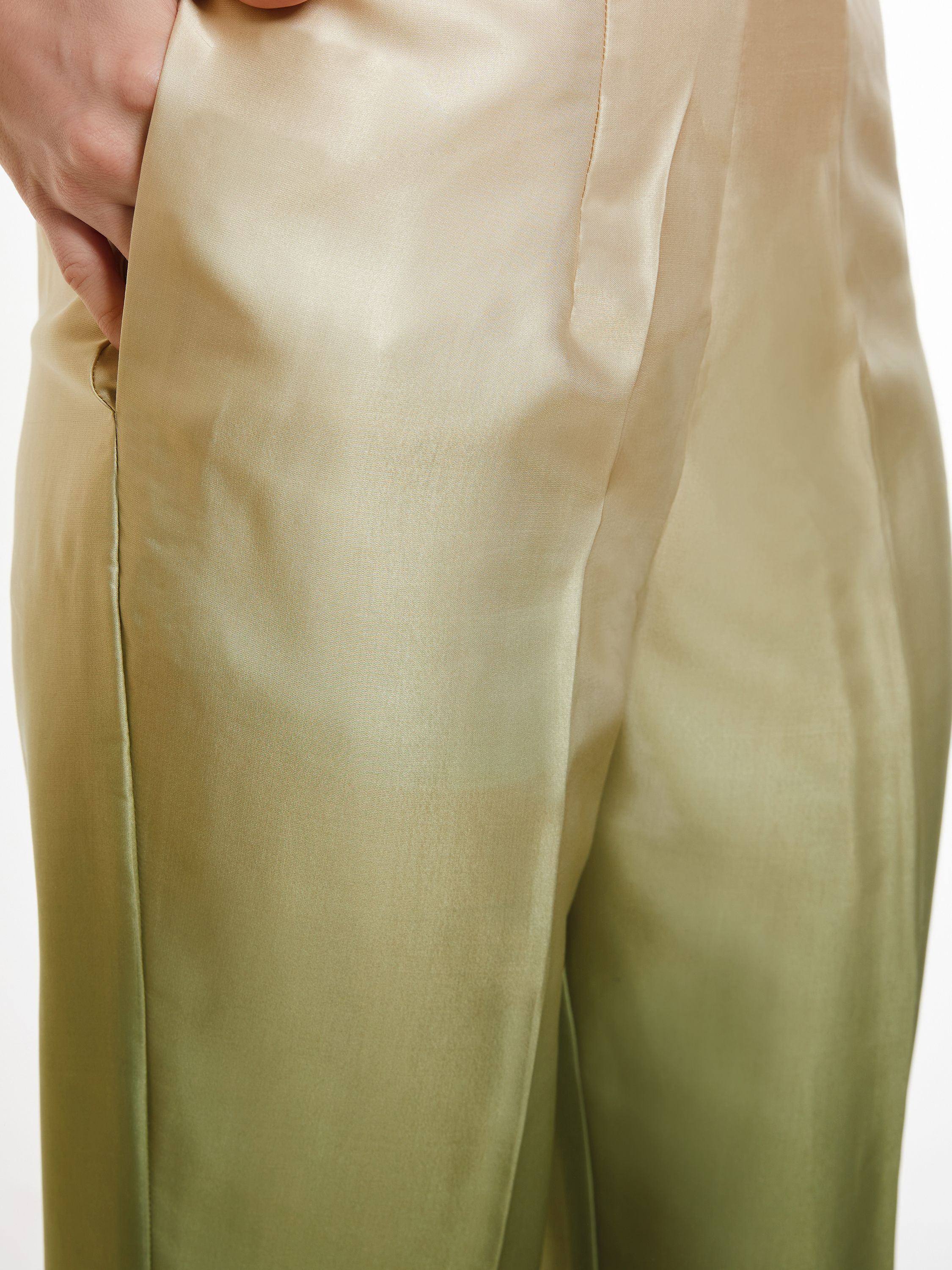 Close-up of hand in pocket of shiny beige and olive green silk trousers for ethnic wear