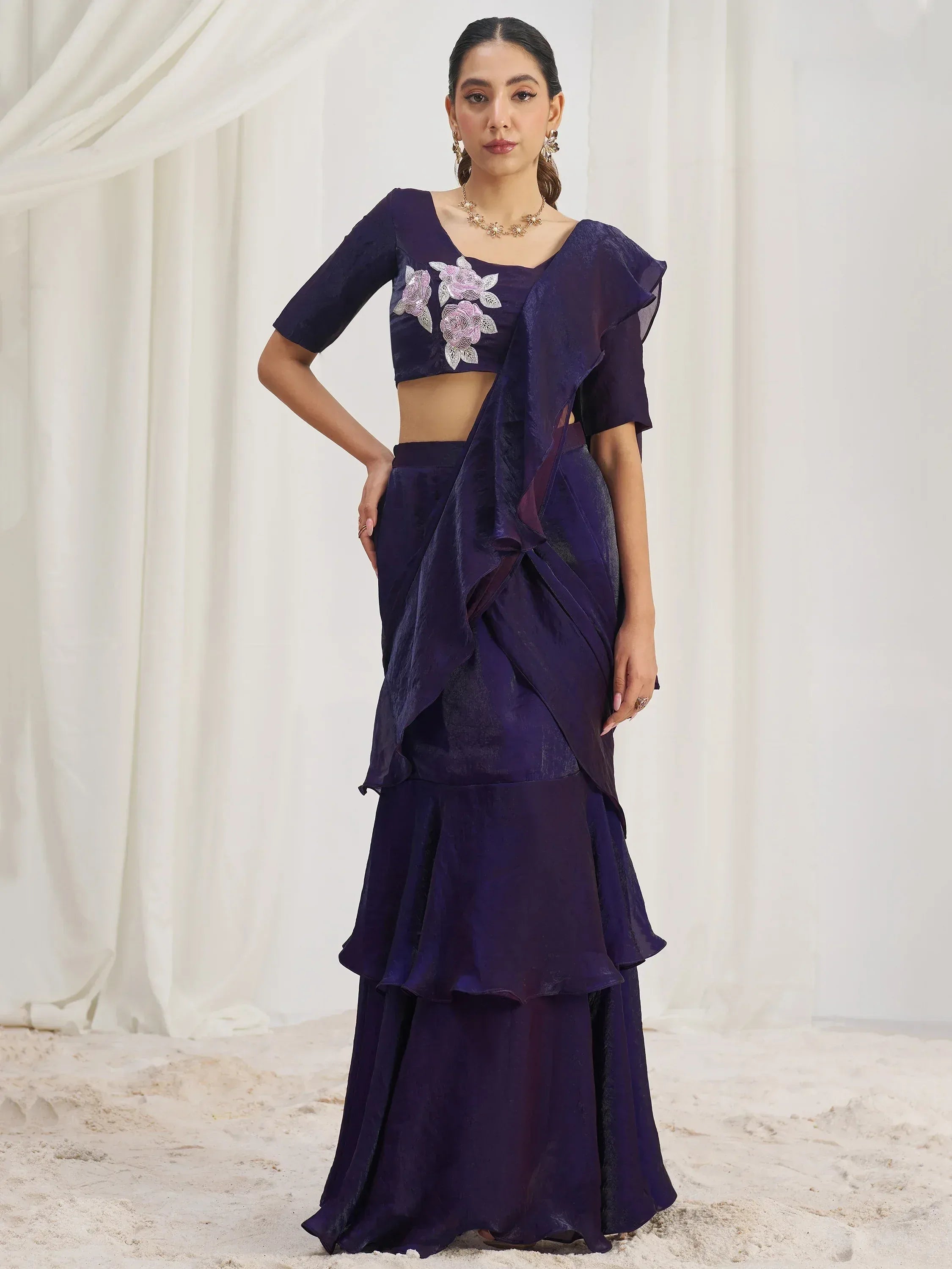 Elegant purple ethnic gown with floral embroidery and ruffled layers, perfect for Indian occasions.